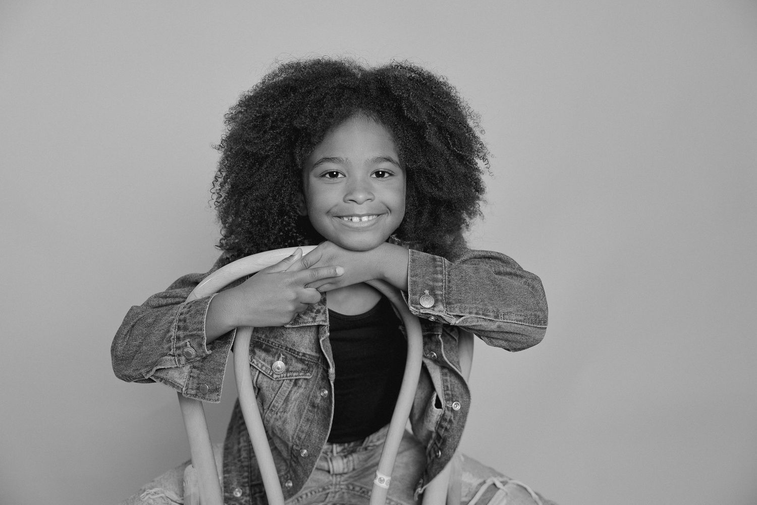 Black and white portrait series showing playful poses with denim jacket.