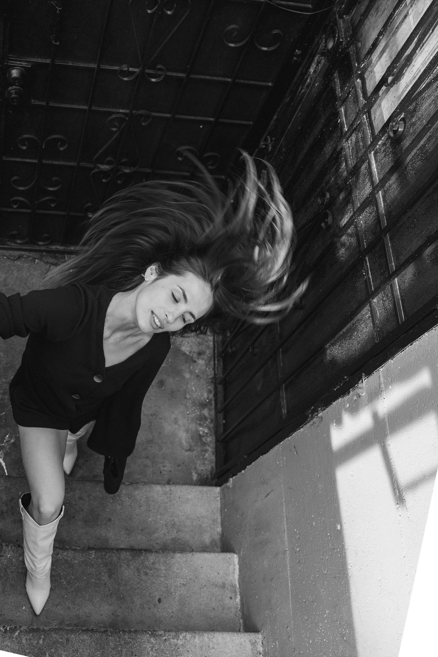 Dramatic black and white photographs on staircase with natural lighting and shadows.