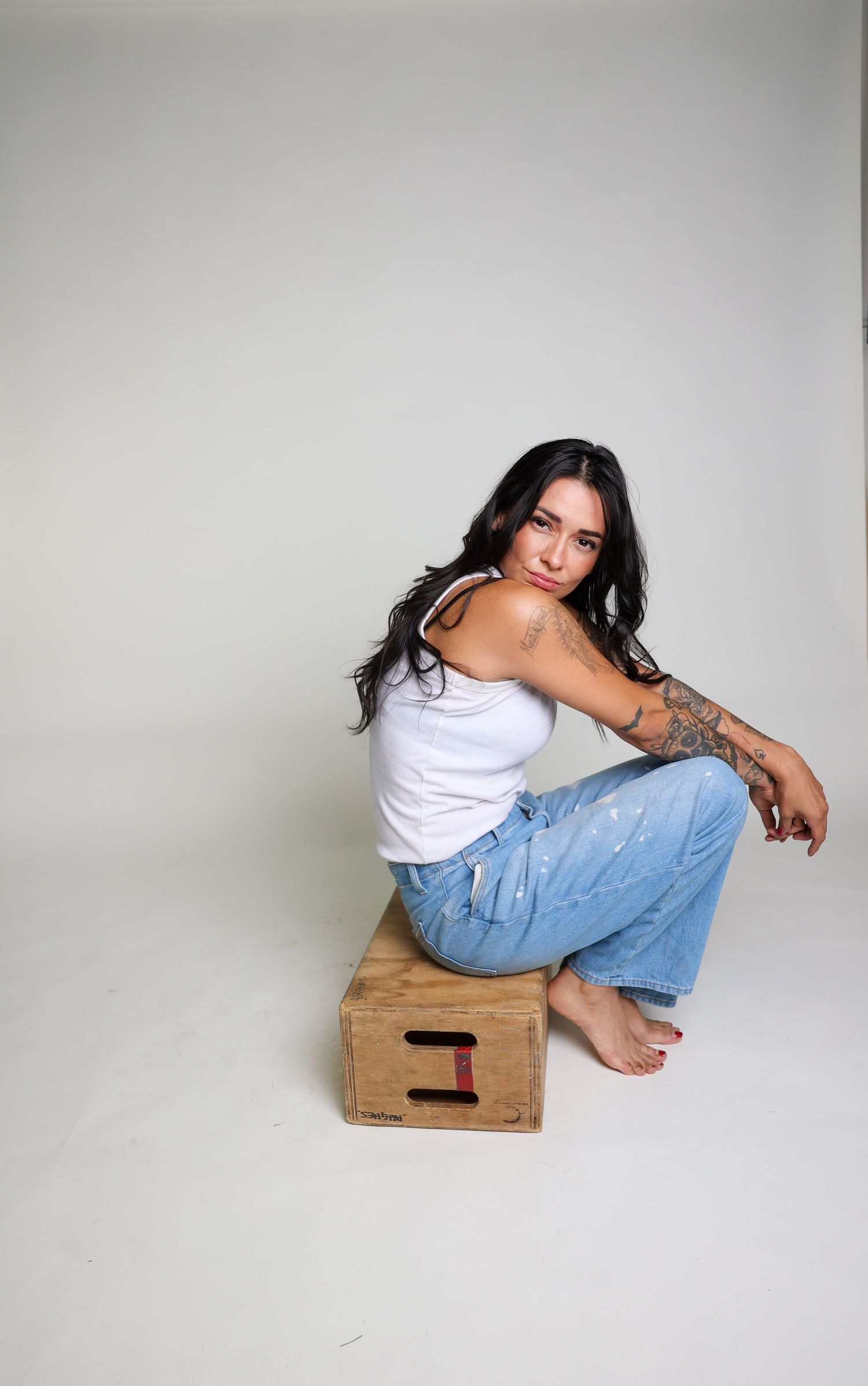 Studio photography series featuring casual styling with wooden crate prop.