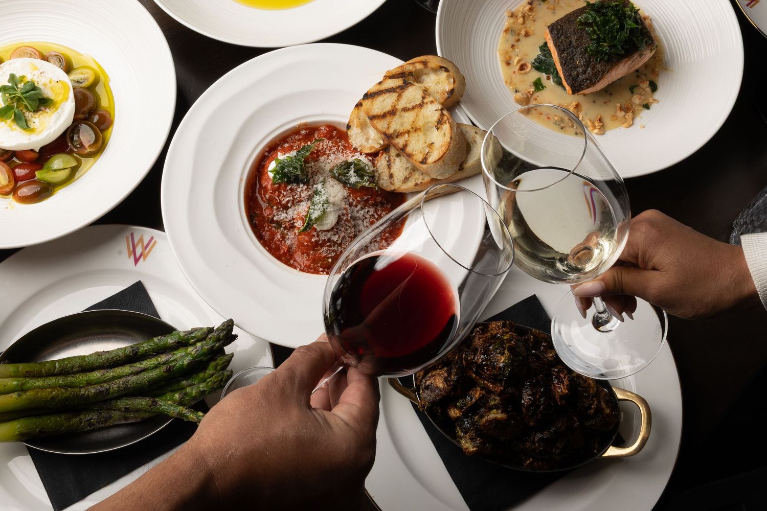 Overhead view of multiple fine dining dishes being served at an upscale restaurant.
