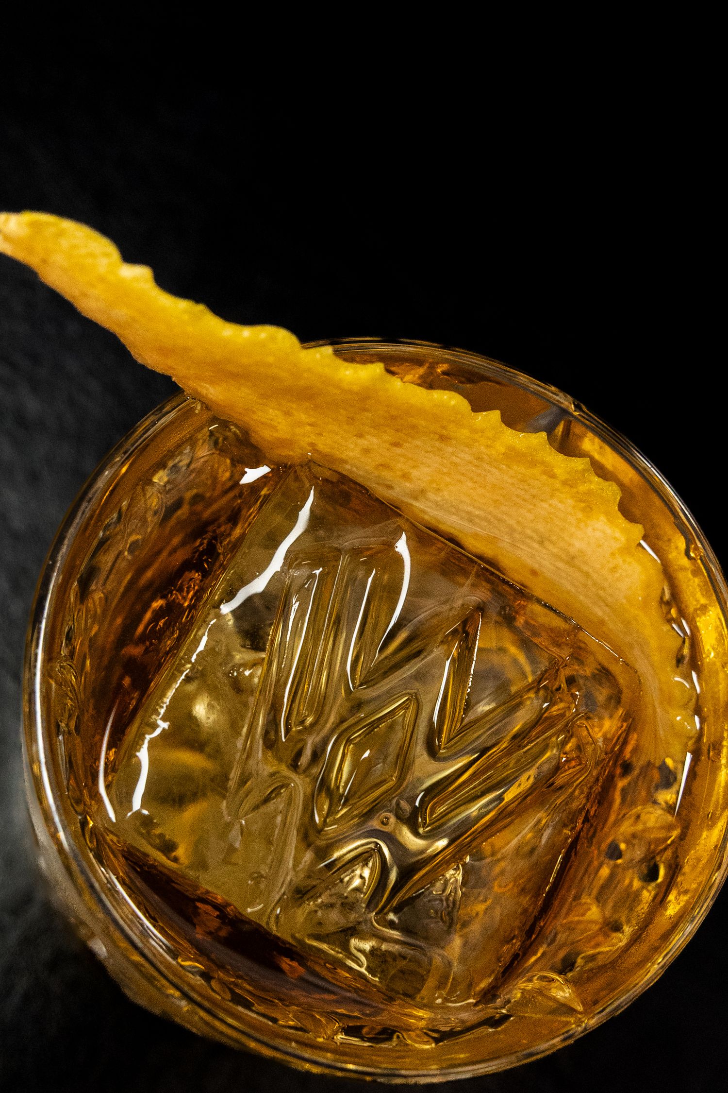 Close-up sequence of an amber-colored cocktail glass with a wavy textured pattern.
