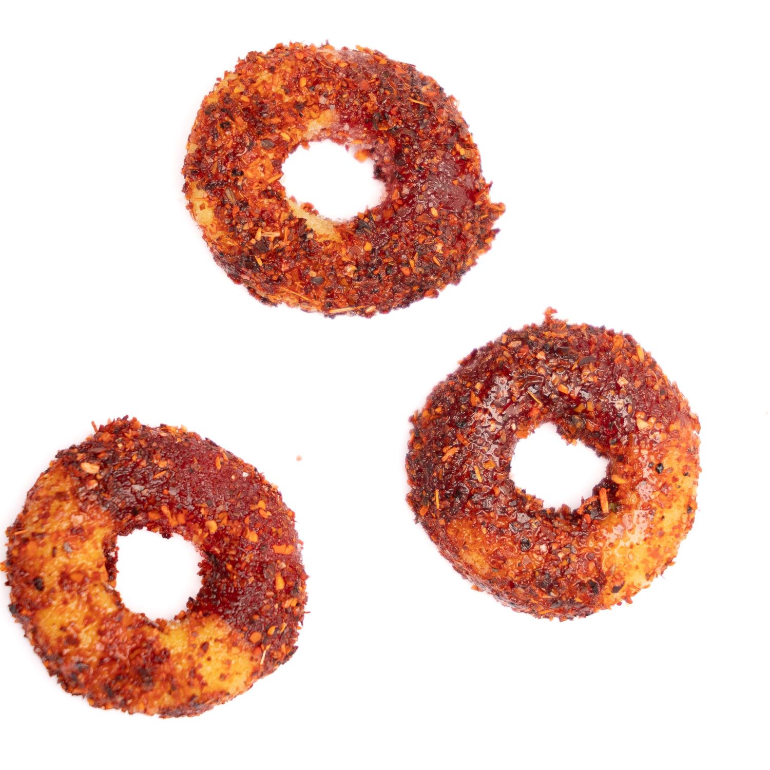 Three ring-shaped spicy-coated snacks displayed on white background.