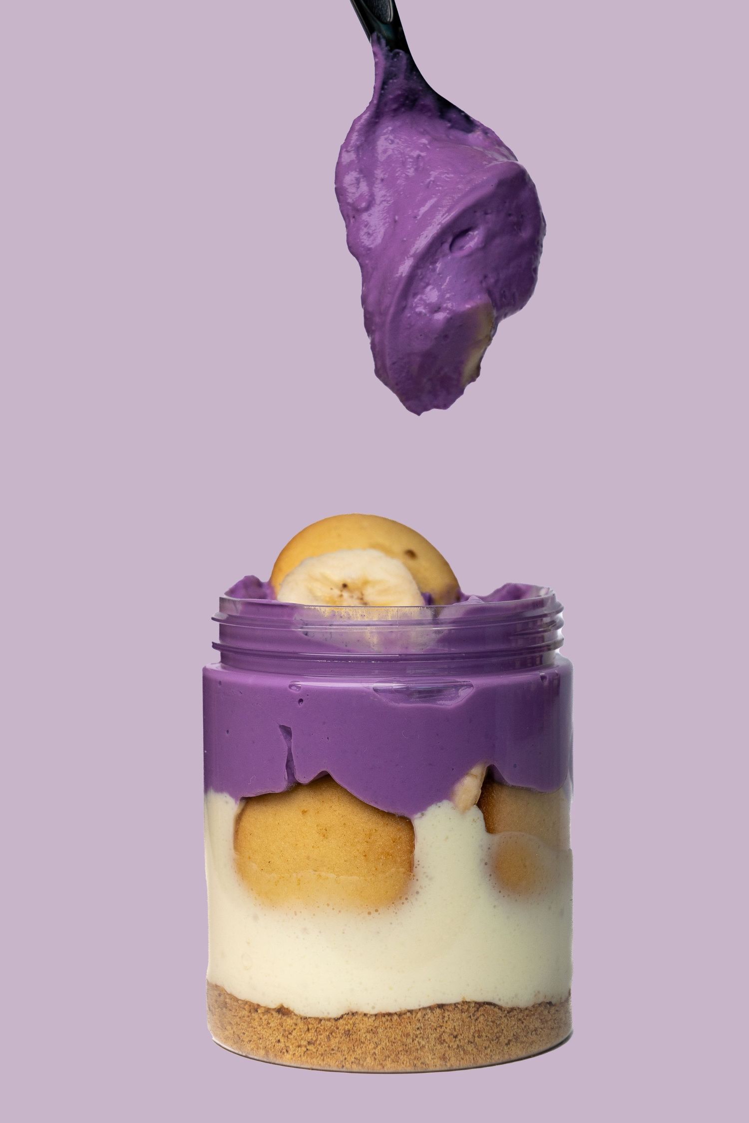 Purple dessert assembly sequence showing layers of cream and cookie base with lemon garnish.