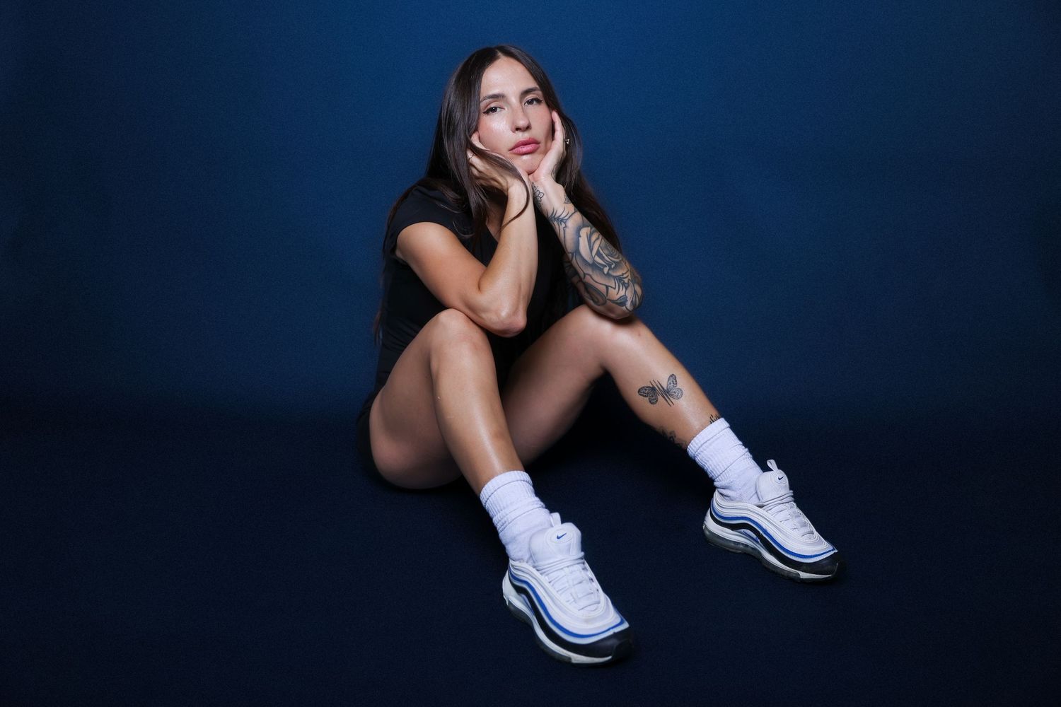 Person in white sneakers sitting against dark blue background in various poses.