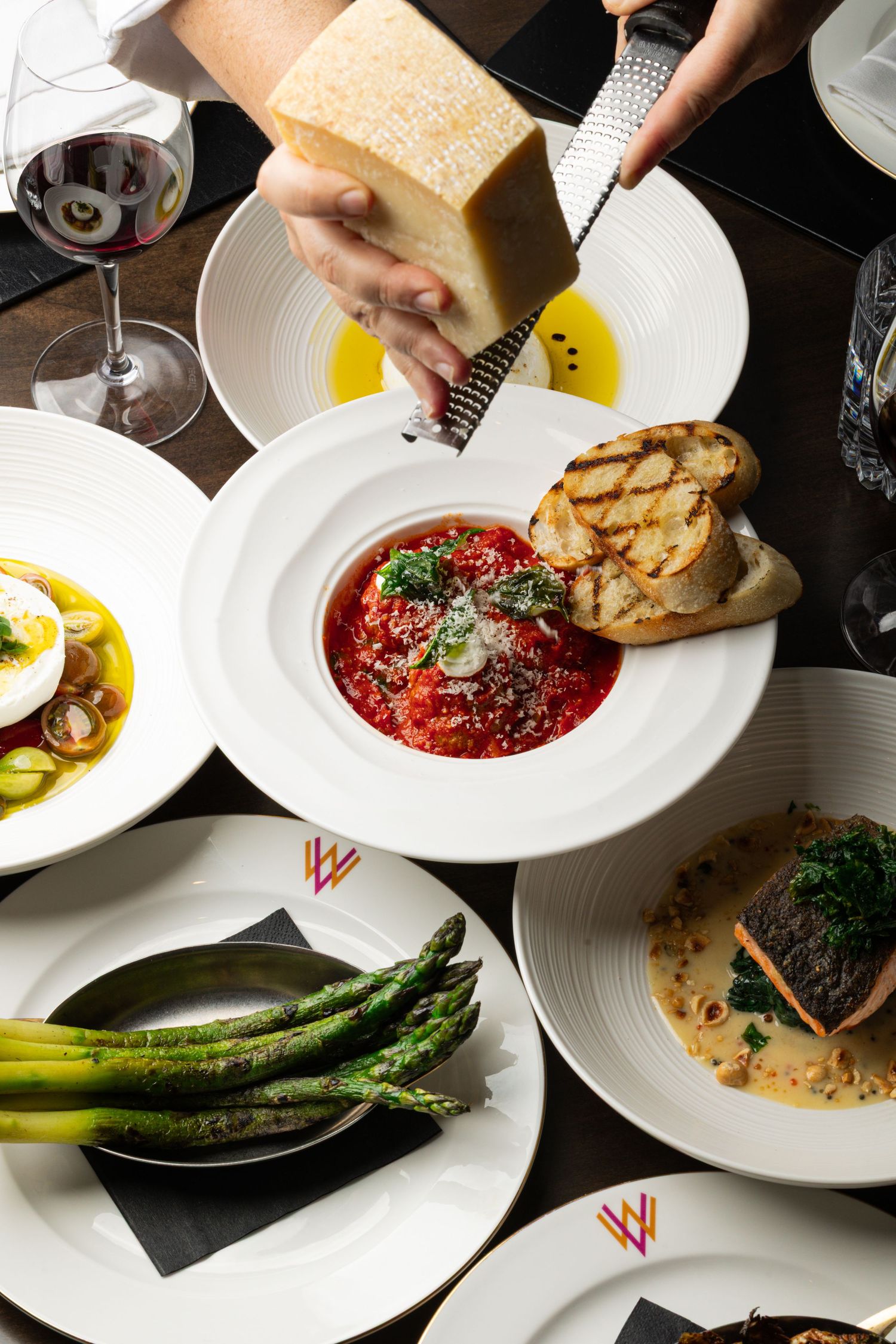 Fine dining experience with multiple courses including asparagus and red sauce dishes.