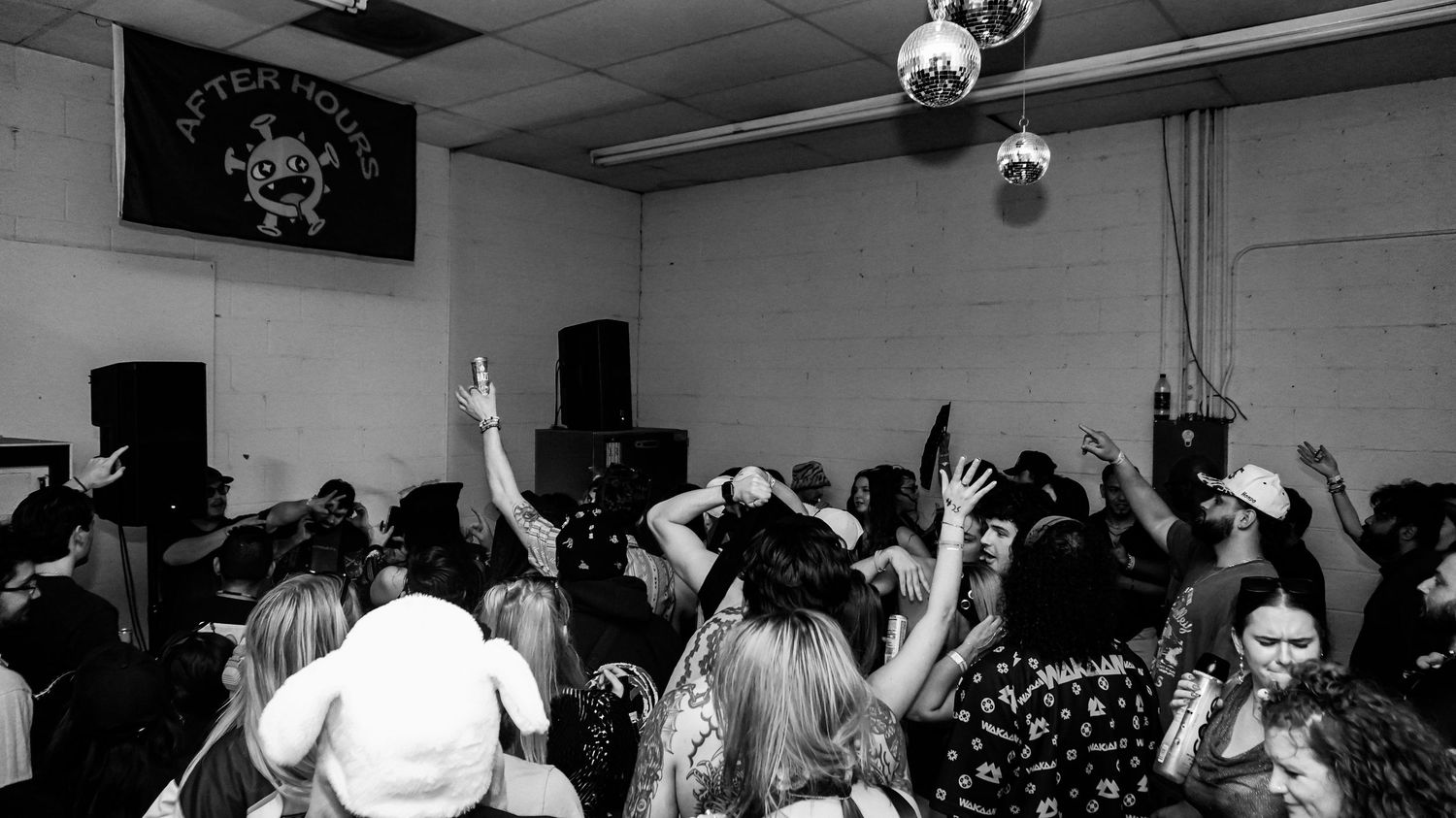 Crowd dancing at After Hours music event in black and white photography.