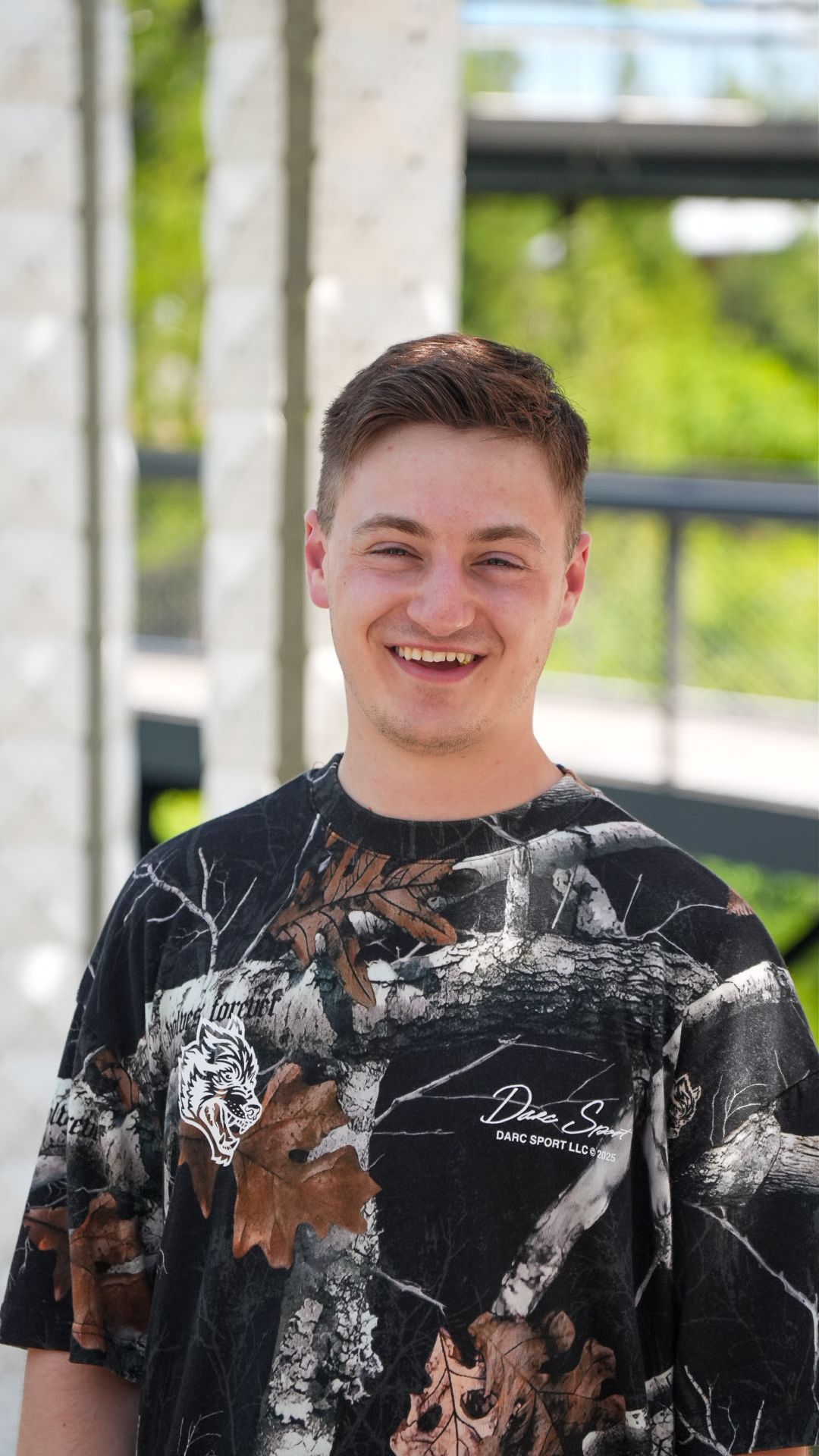 Headshot portrait of man smiling in park