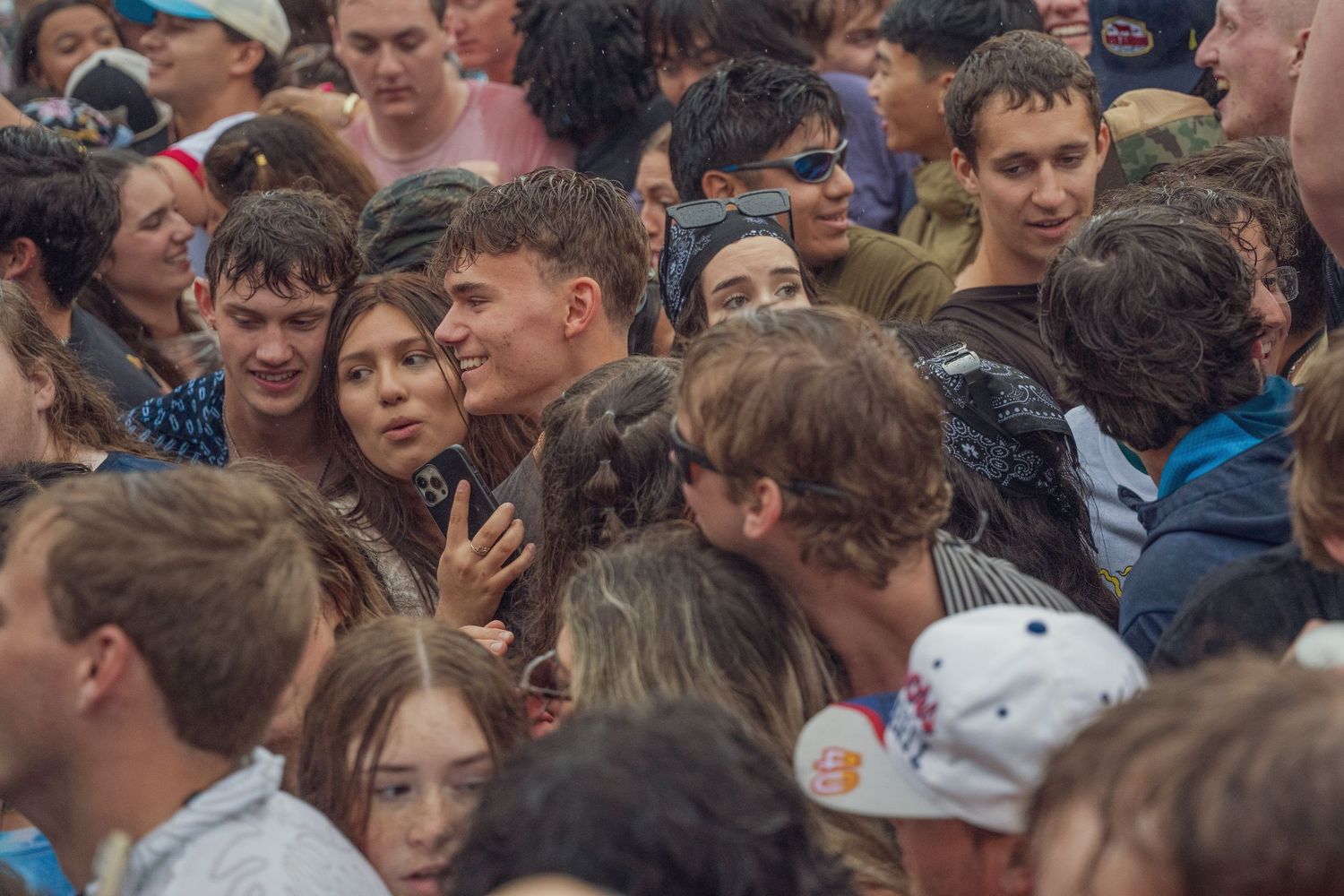 A large crowd of young people packed together at an outdoor music festival.