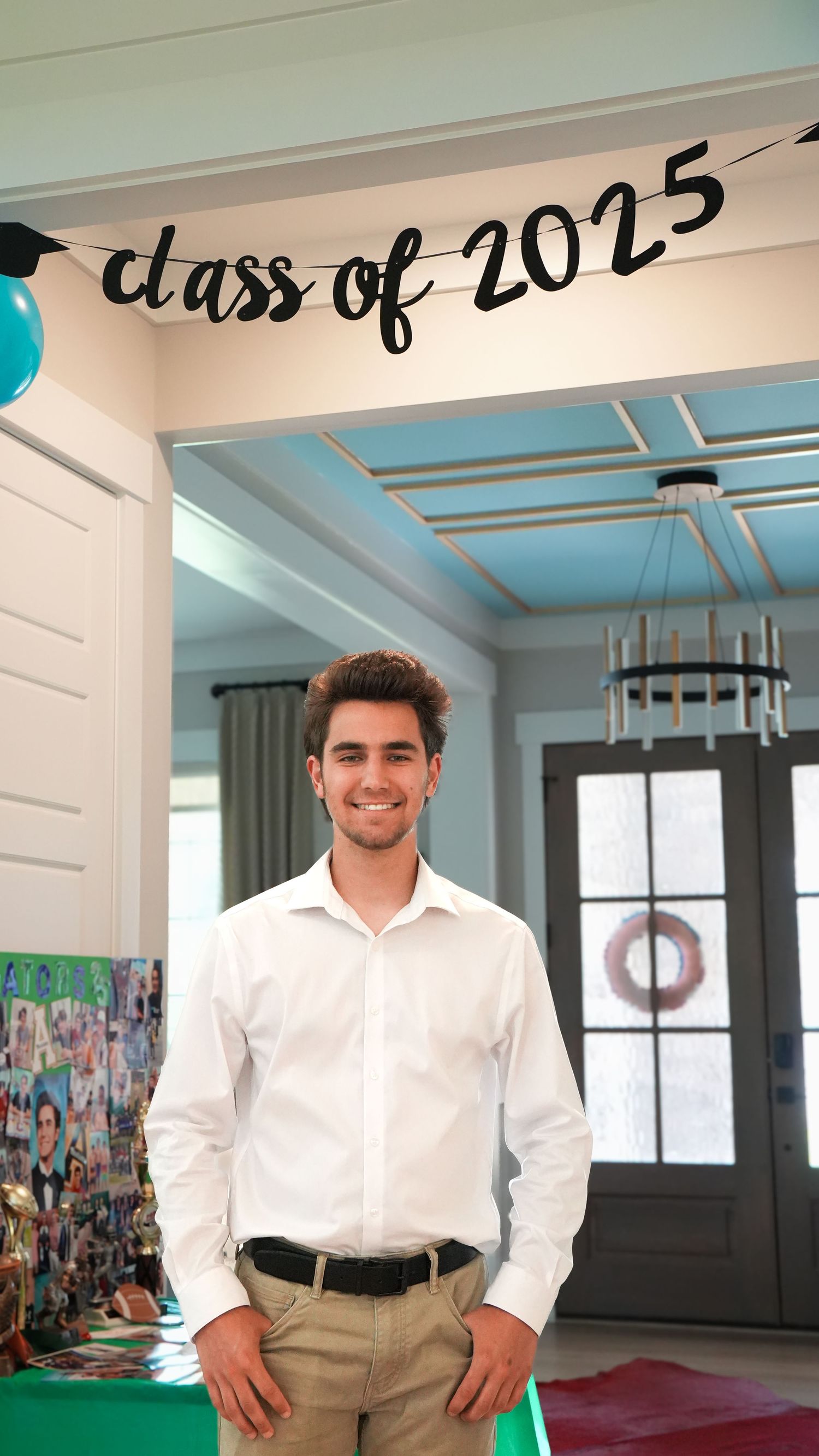 Young man at home graduation party with class of 2025 banner in background