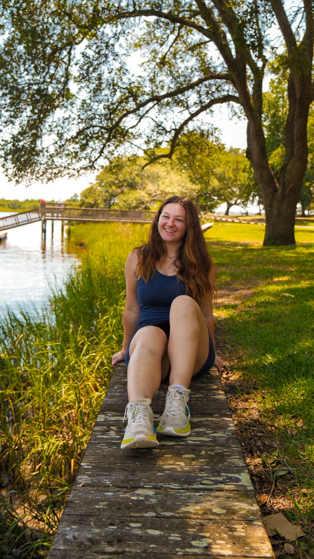 Woman sitting on ledge next to waterway