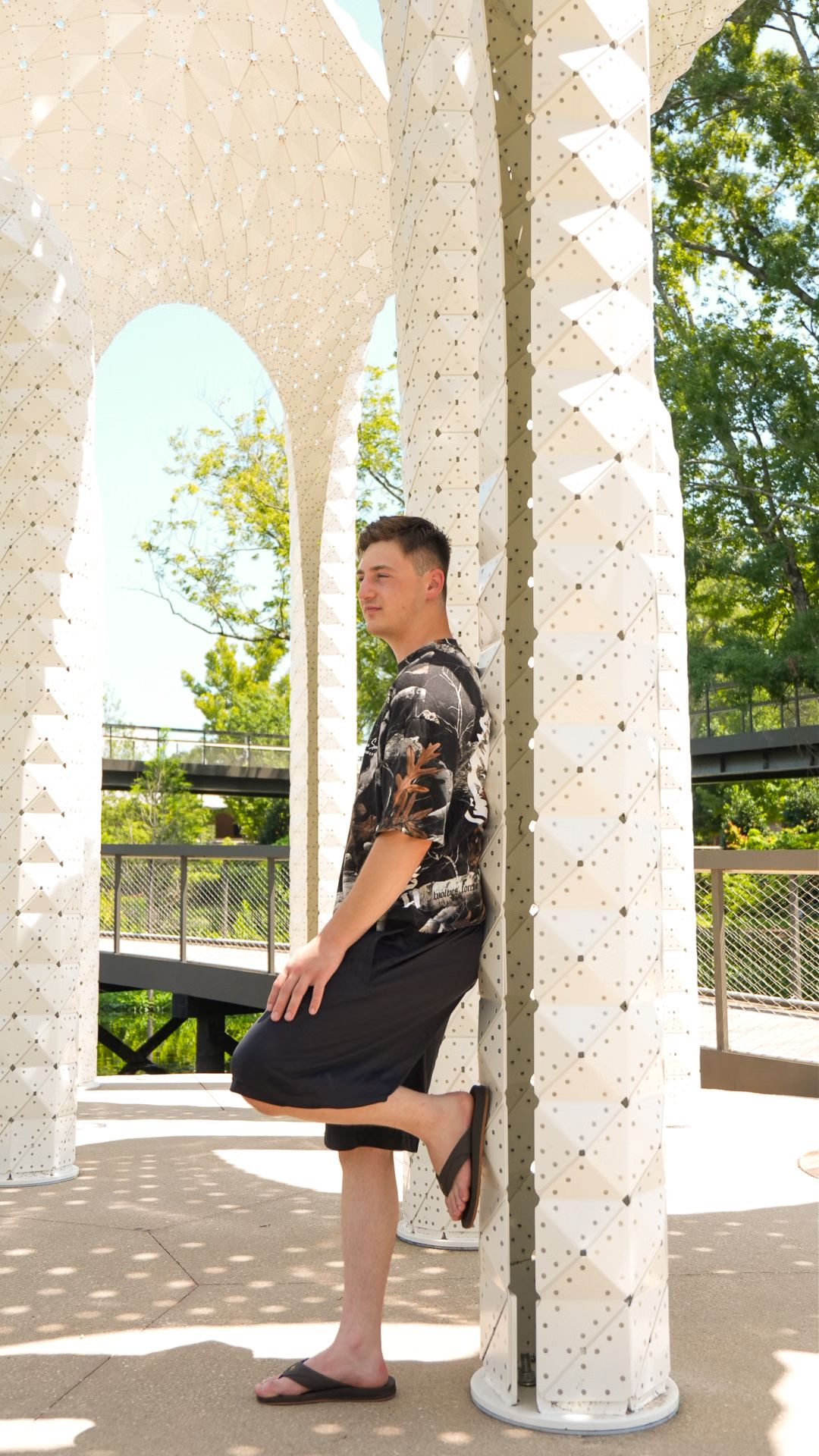 Man leaning on art sculpture in park