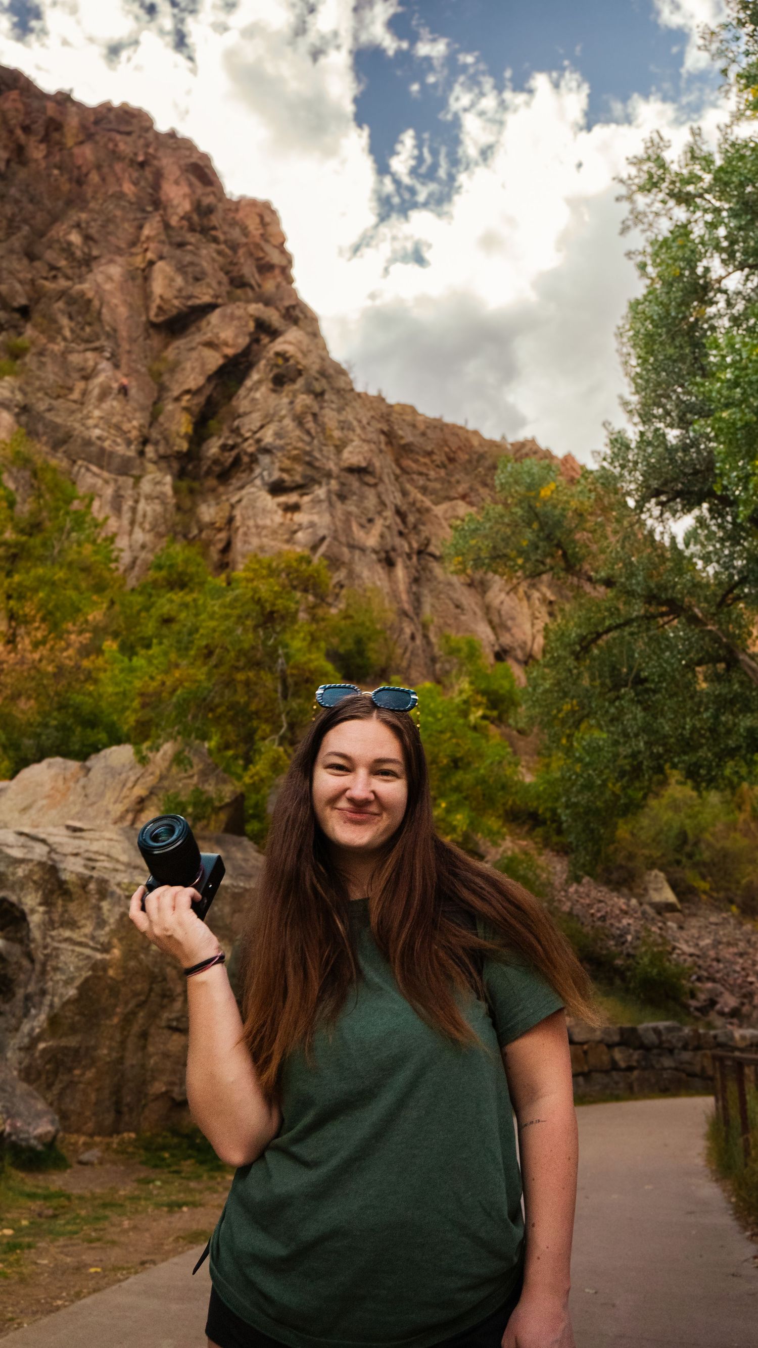 Woman holding camera in front of mountainside