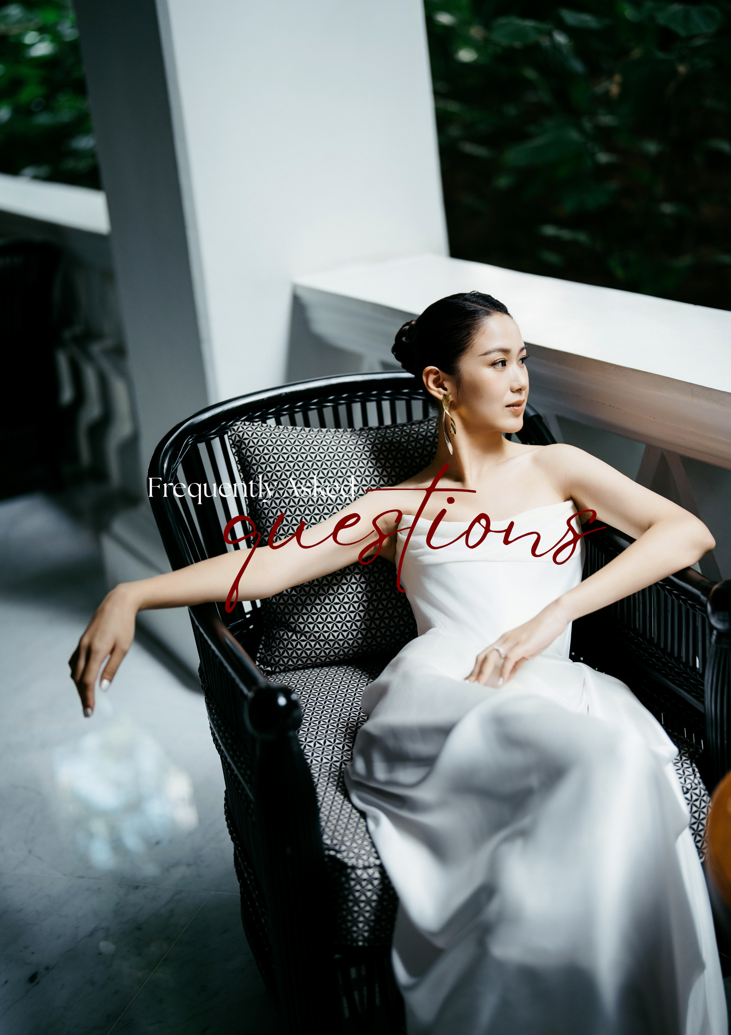 Elegant bride in white satin gown seated in black wicker chair, FAQ overlay text, lush greenery background.