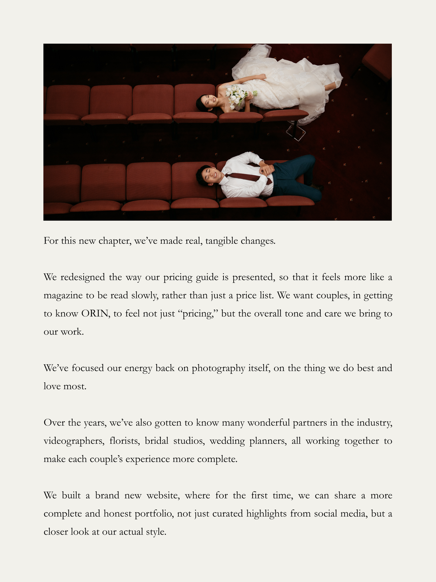 Bride and groom in elegant wedding attire posed dramatically on a dark velvet sofa for a stylish editorial shoot.