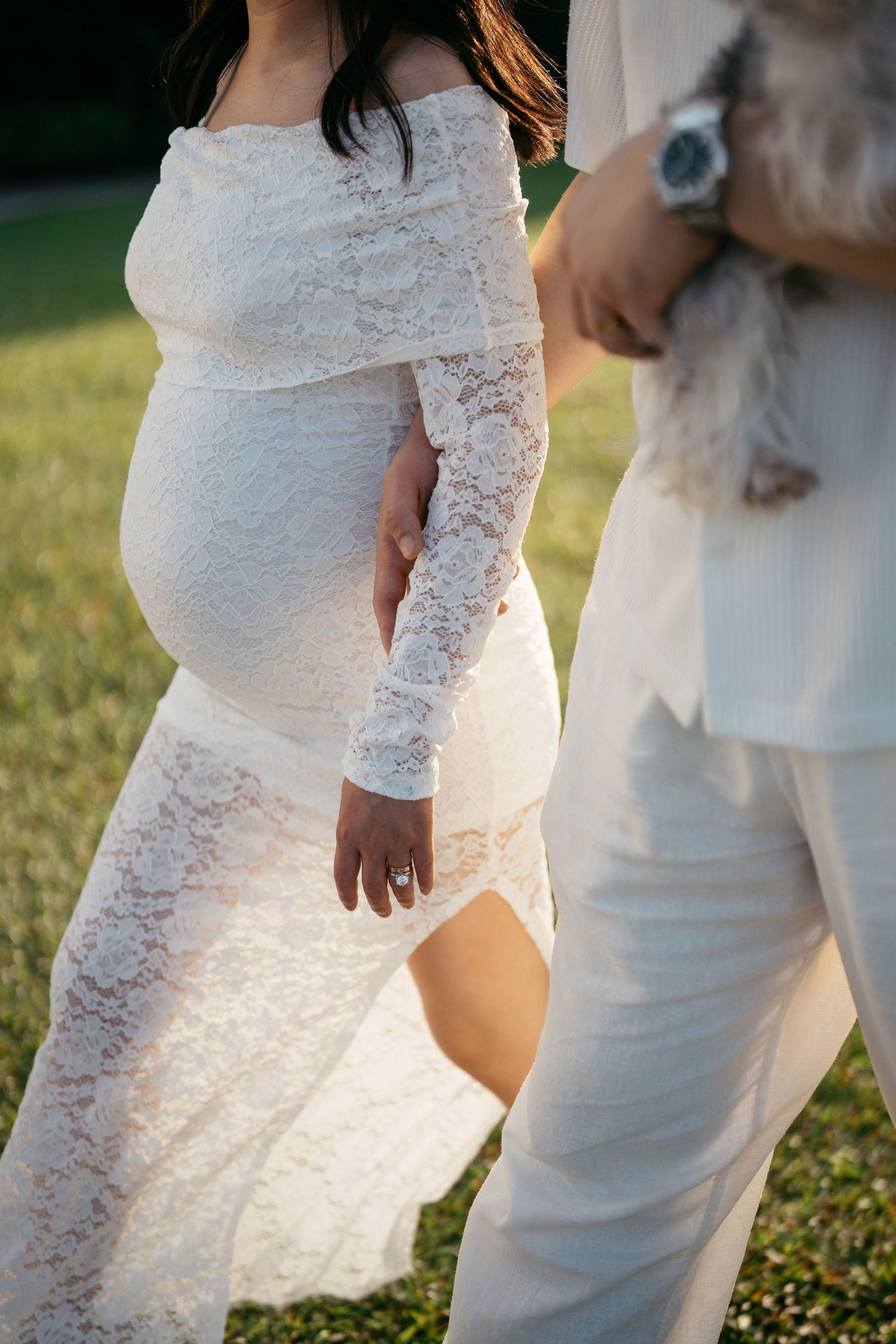 Detail shot of white lace wedding dress against soft natural lighting.