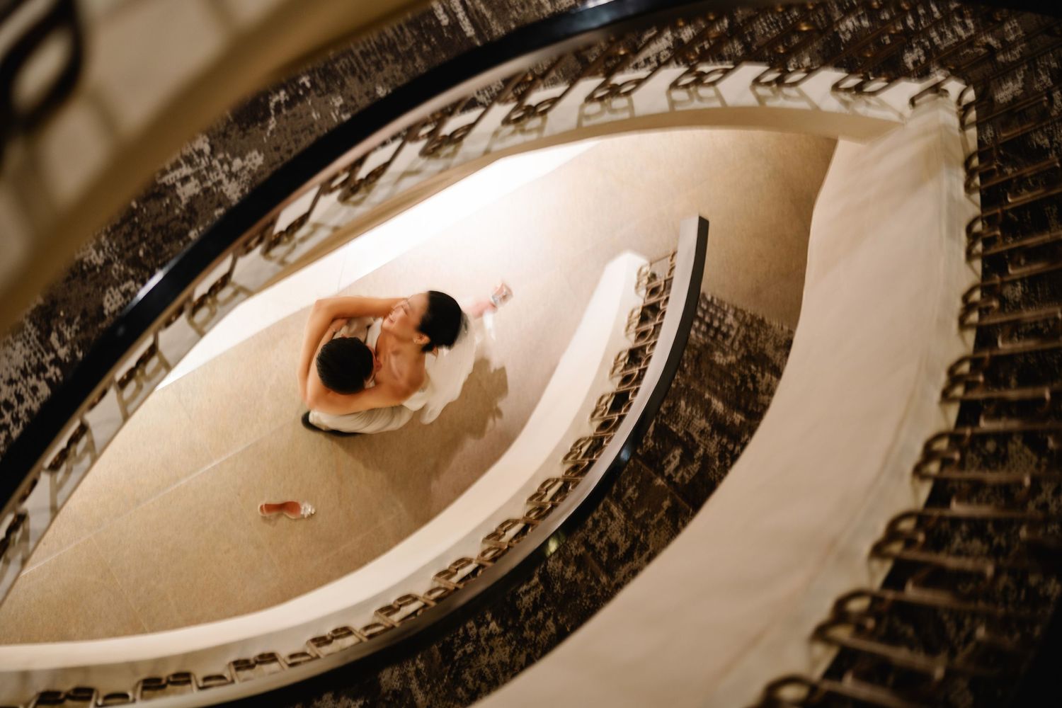 Artistic overhead spiral view of a curved staircase in sepia tones.
