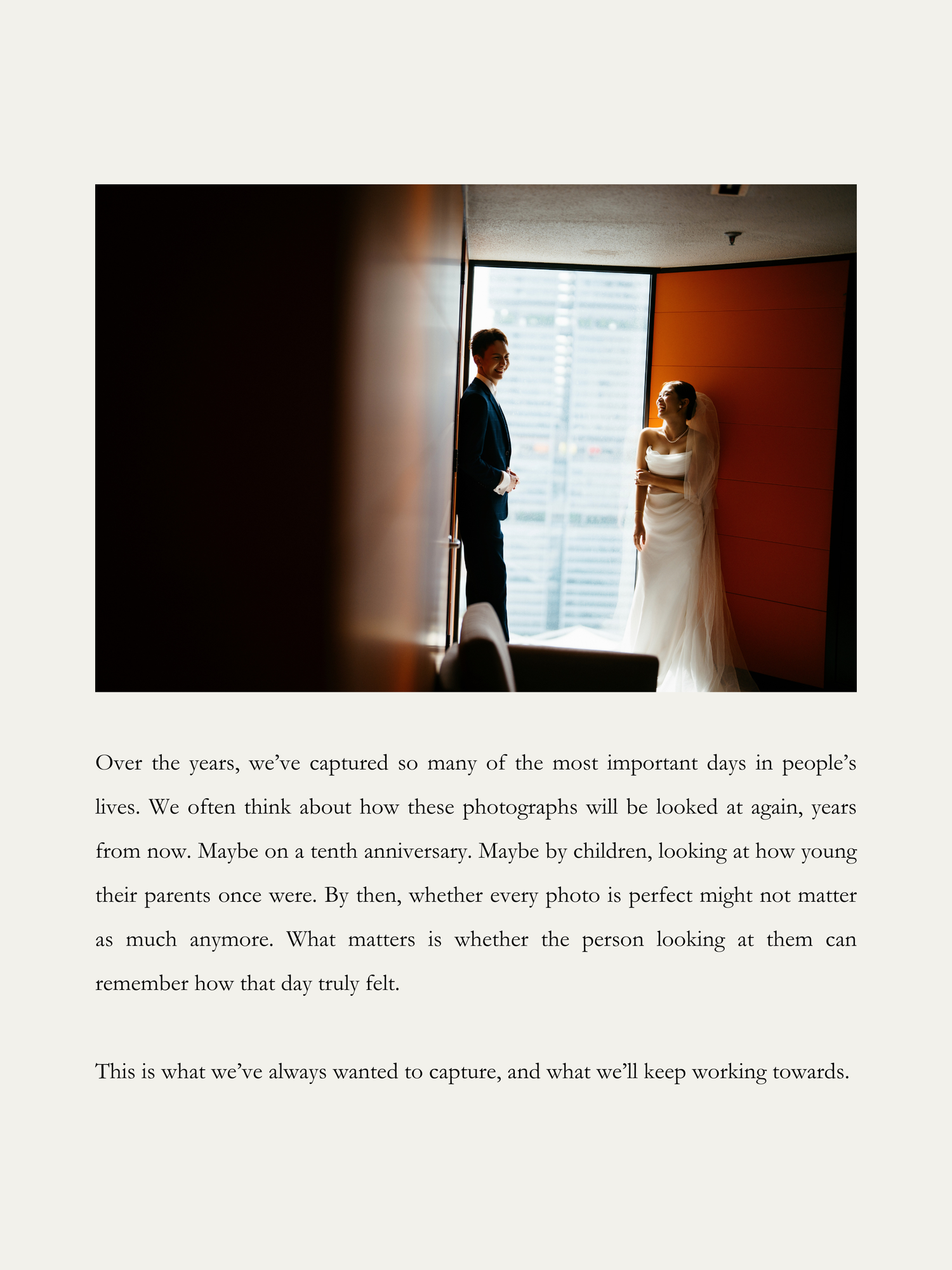 Silhouetted bride and groom standing by a large window, sharing a romantic moment on their wedding day.