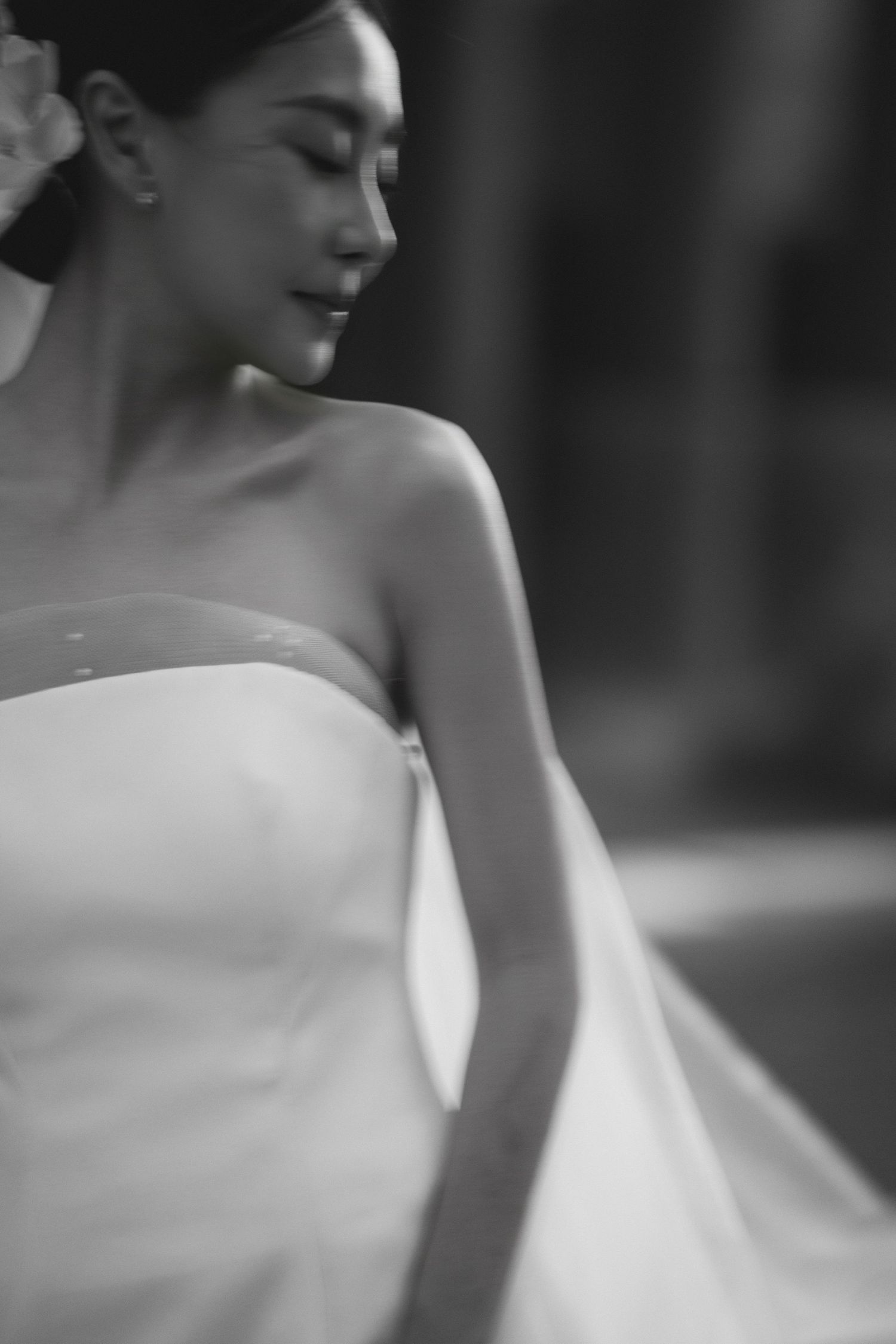 Black and white portrait of a bride in a strapless wedding gown with elegant minimal styling.