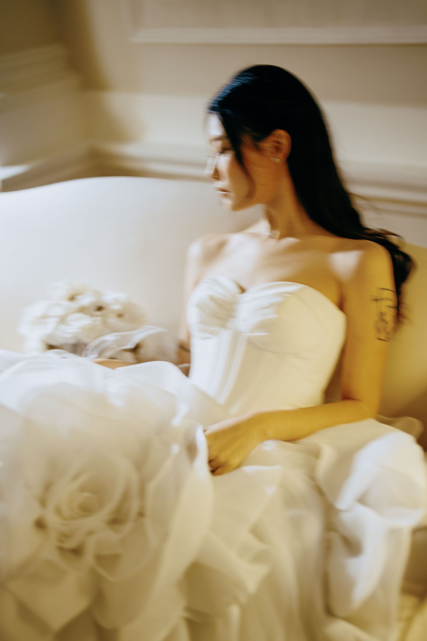 A soft and dreamy sequence showing a figure in white reclining on plush bedding with delicate floral accents.