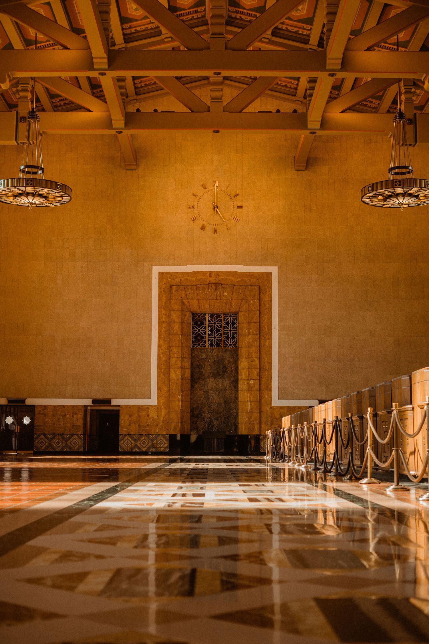 Grand interior hall of Union Station with marble floors, wood beam ceiling, and a clock.