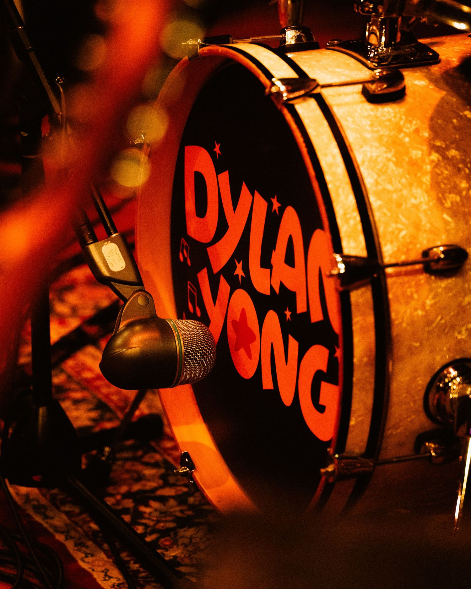 Close-up of Dylan Yong branded bass drum on stage during live music performance.
