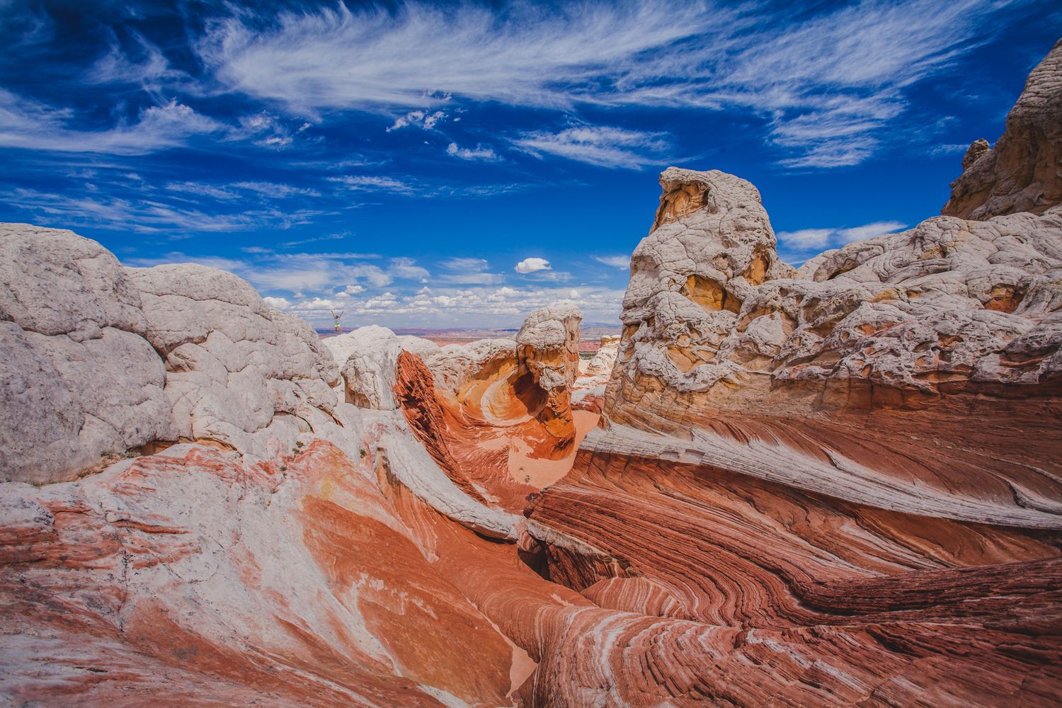 Stunning red and white swirling sandstone rock formations at White Pocket, Arizona under a vivid blue sky.