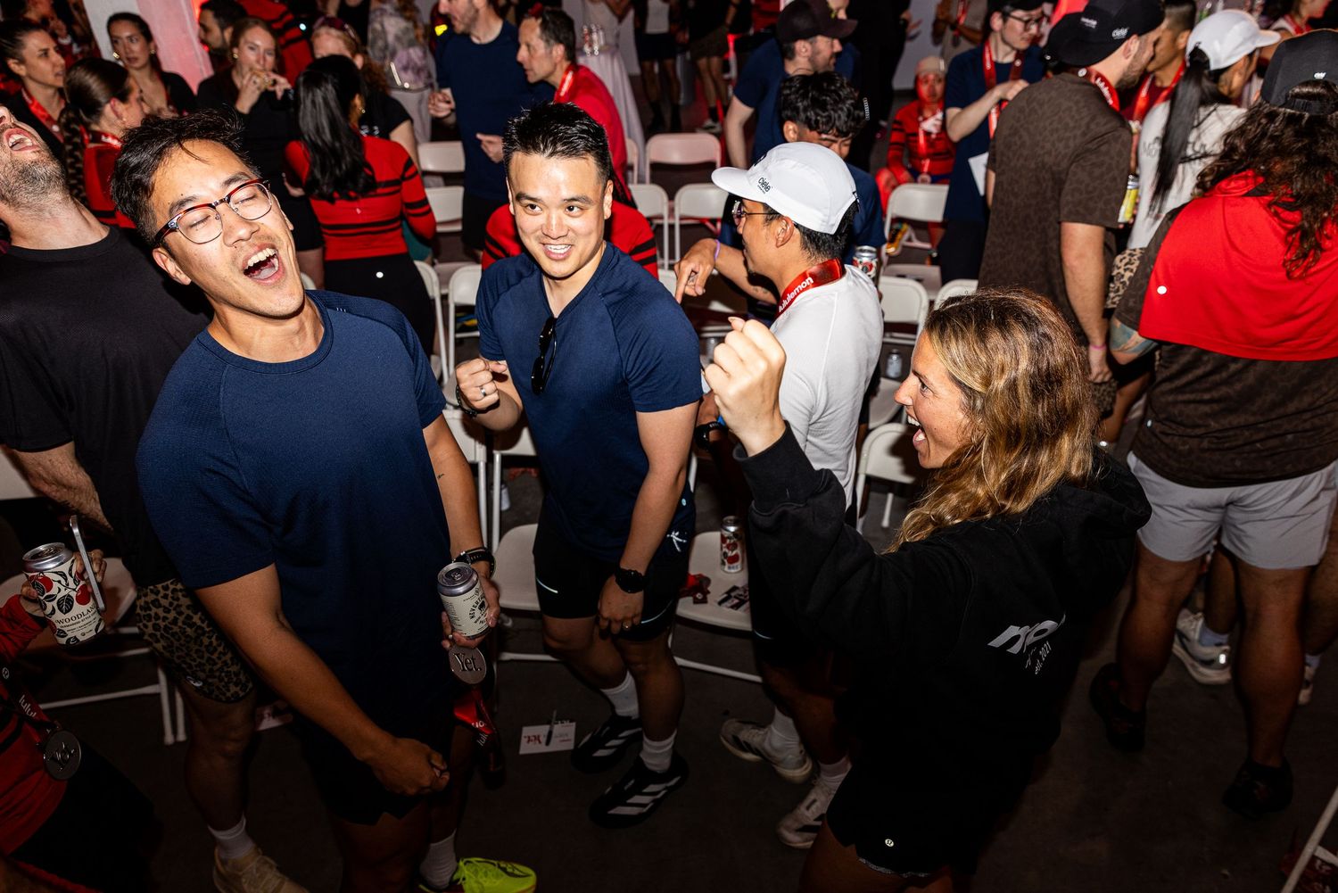 Excited young people laughing and celebrating together at a lively indoor social event.