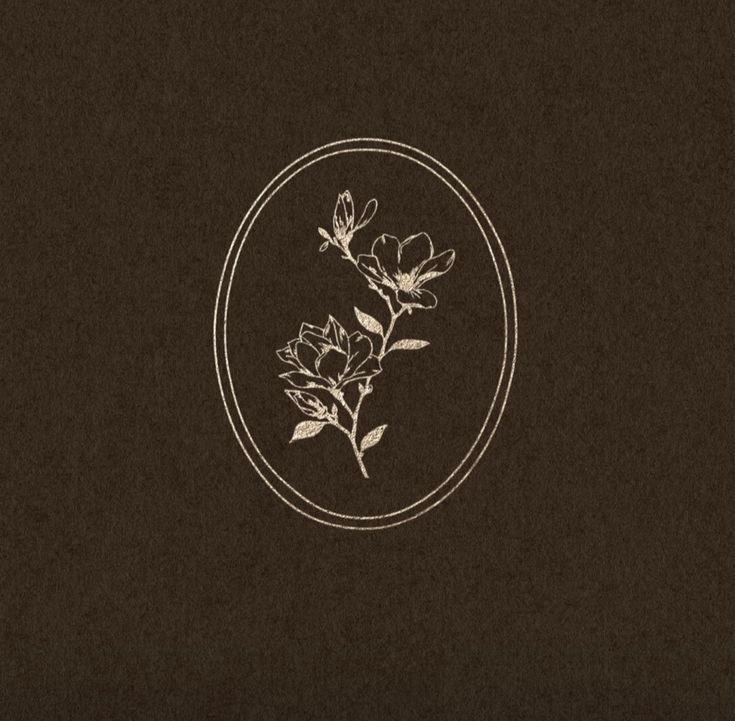 Gold botanical floral illustration inside an oval frame on a dark brown textured background.