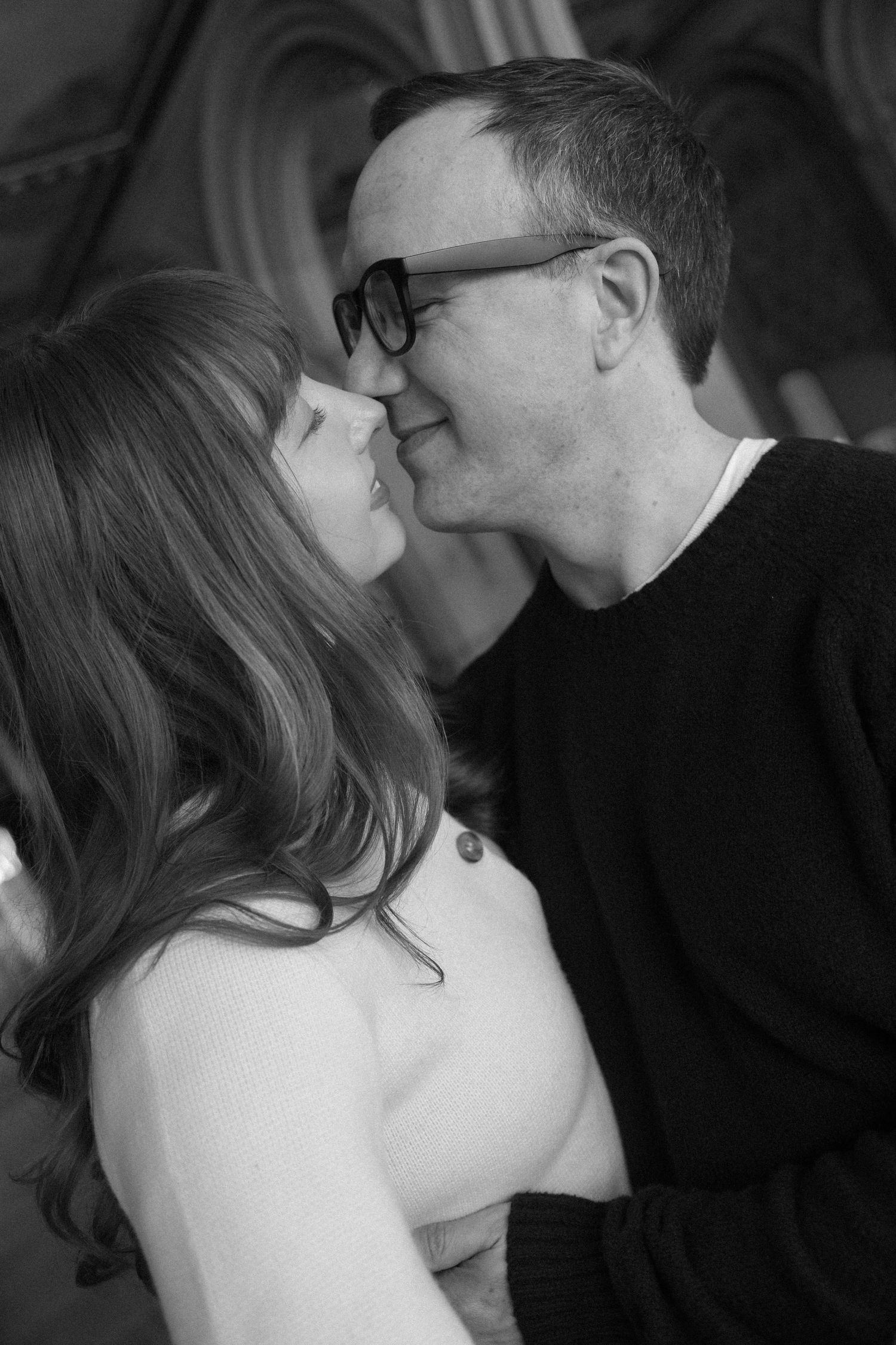 Black and white close-up of couple sharing a tender kiss inside ornate Bethesda Terrace, Central Park.