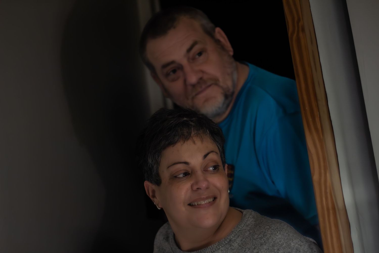 Two people sharing a warm moment together in a dimly lit room.