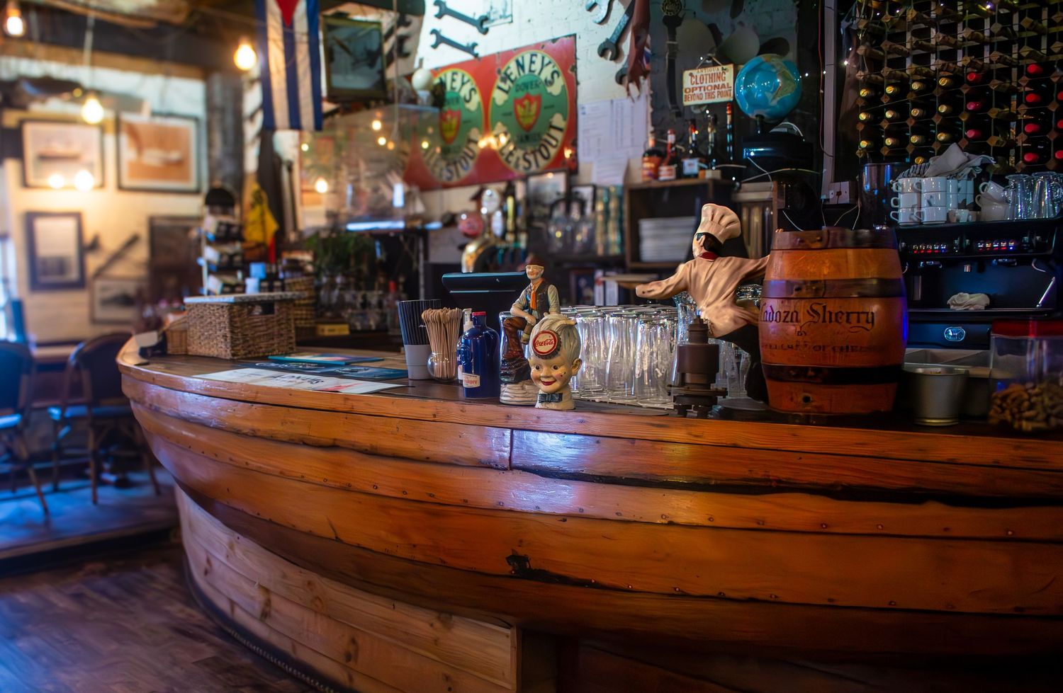 Long wooden bar counter with ambient lighting and classic pub atmosphere.