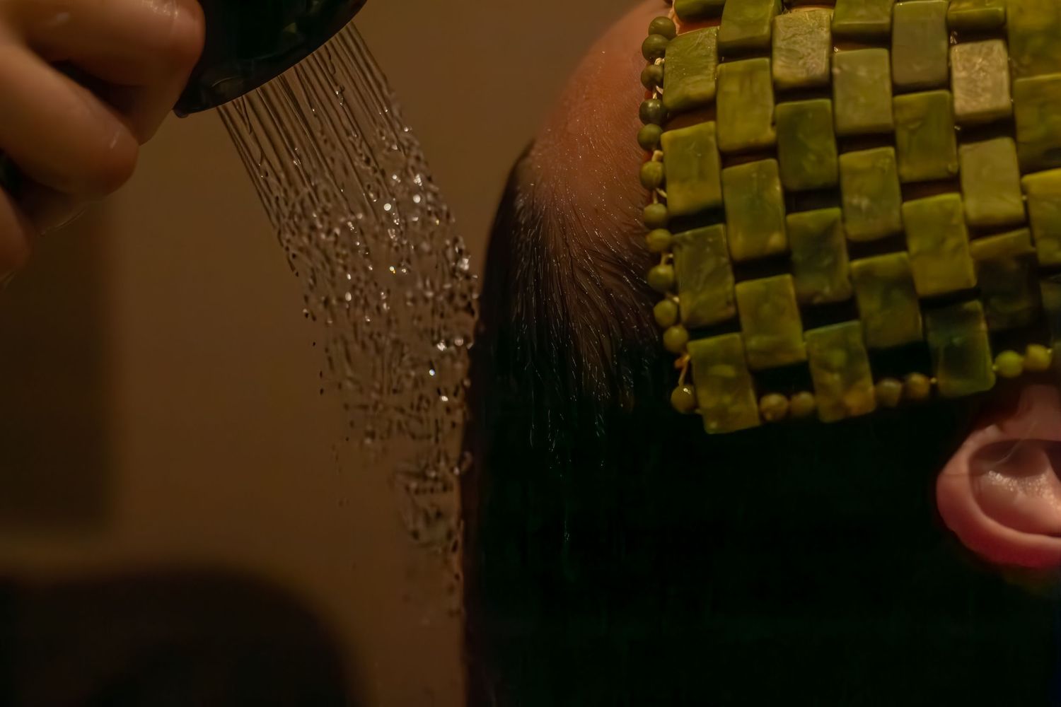 Water droplets splashing on a textured green surface in a spa setting.