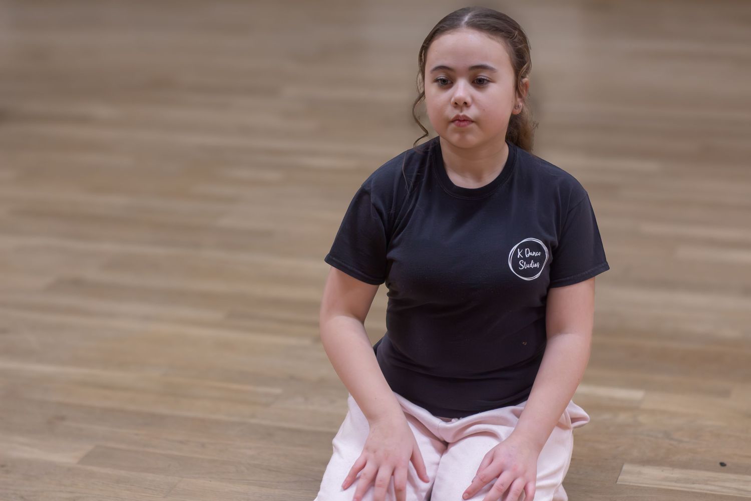 Dancers in black attire practicing choreography in a dance studio.