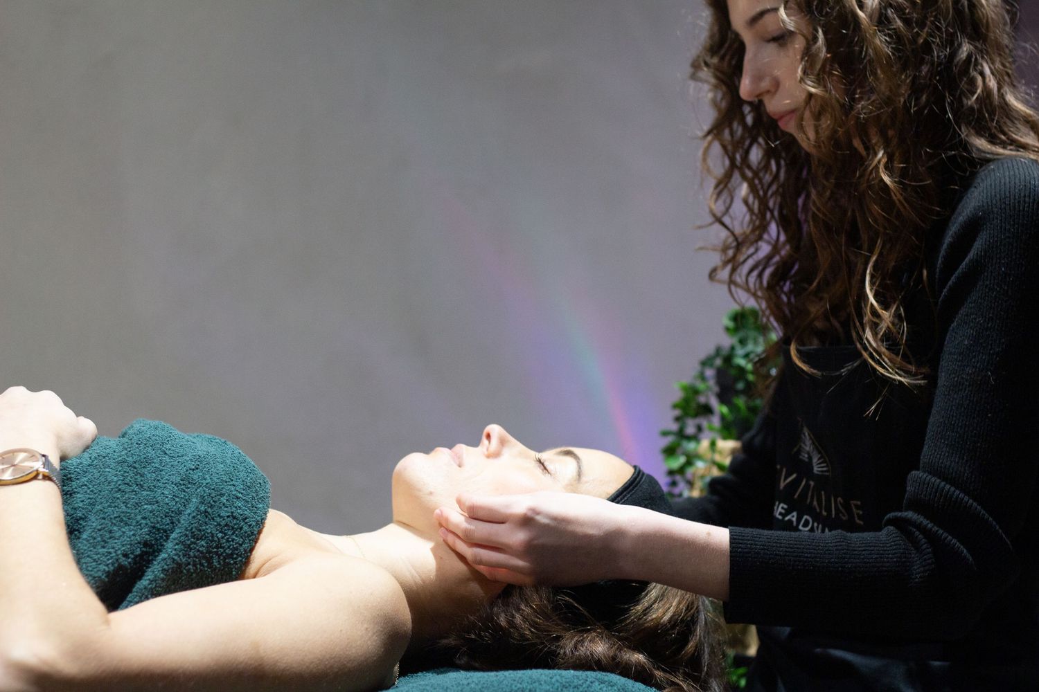 Professional massage therapist working in a dimly lit spa environment.