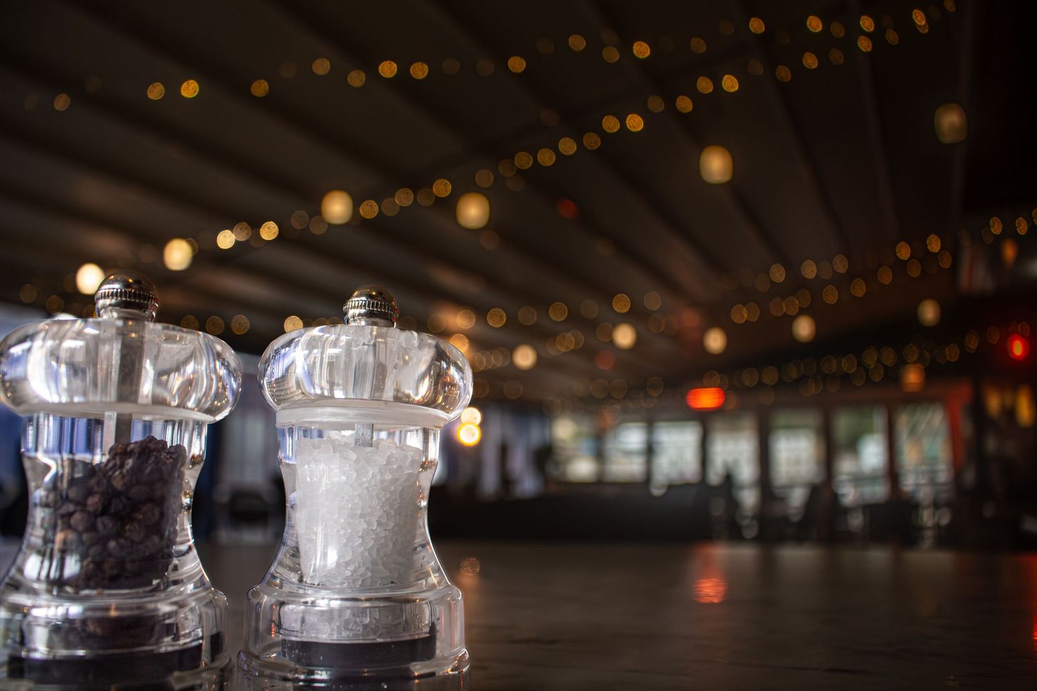 Elegant glass display cases illuminated by ambient string lights in a dark setting.