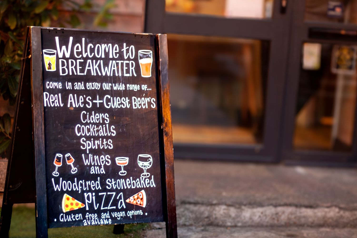 Chalkboard menu sign displaying welcome message and food offerings.