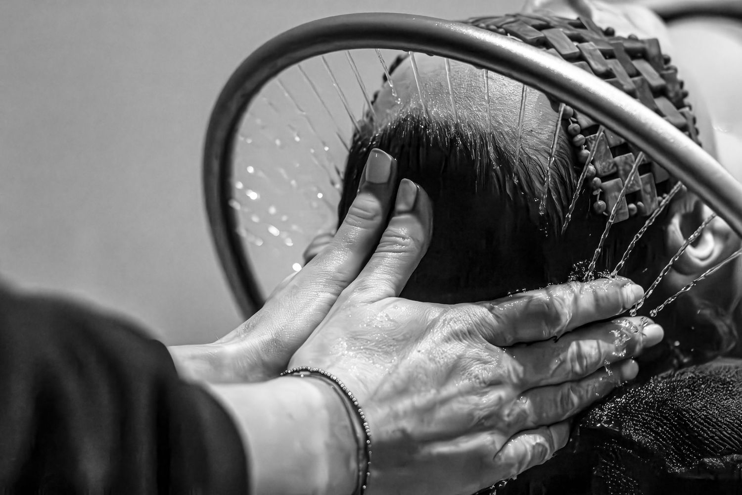 Black and white image of hands performing a therapeutic massage treatment.