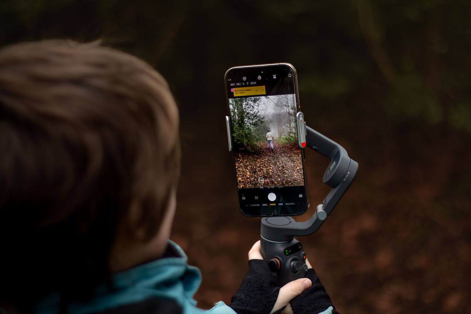 Someone holding a camera to capture nature photos in the woods.