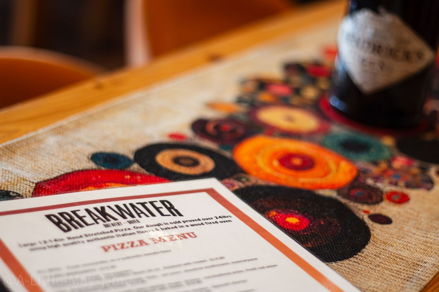 Close-up of a restaurant menu with colorful floral pattern design on a textured surface.