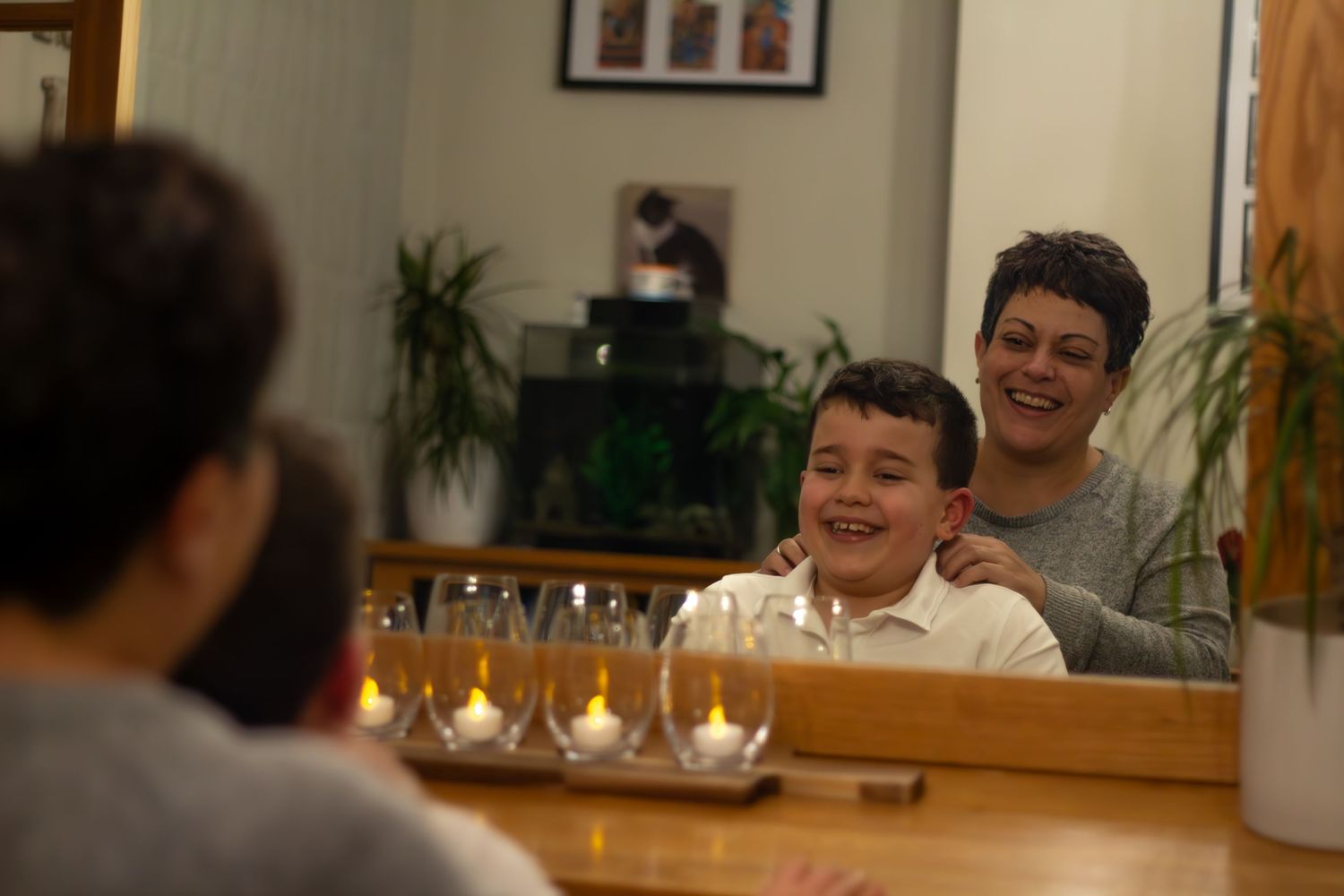A joyful moment of laughter shared around a table with wine glasses.
