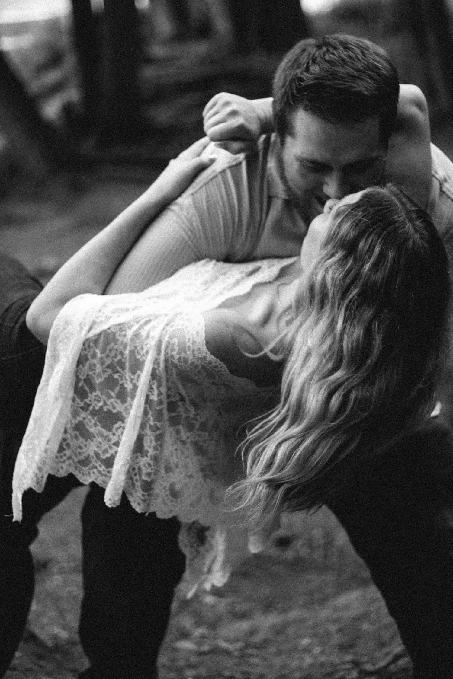 Black and white photo of a romantic couple sharing a passionate kiss, with the man dipping the woman gracefully.