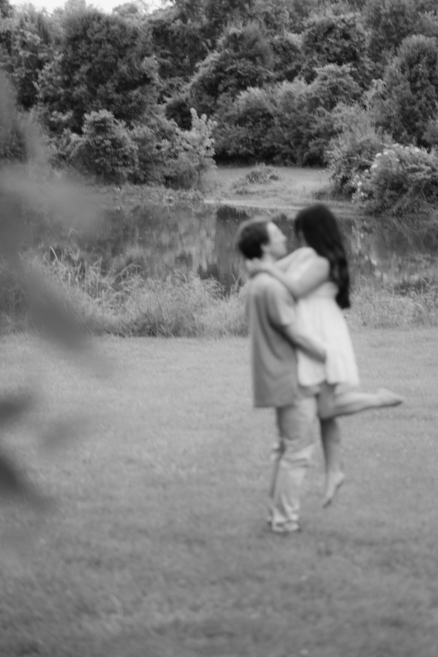 Knoxville Couple laughing together in a grassy field during their engagement photos.