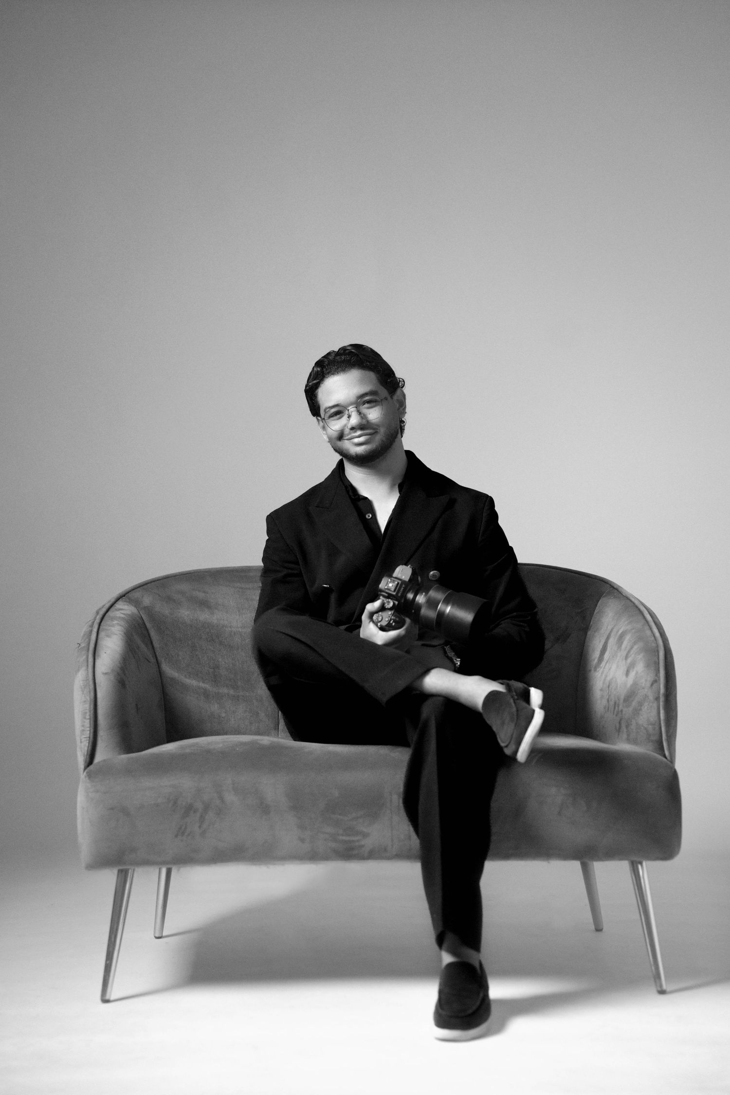 A black-and-white editorial portrait of José Ayala, captured with relaxed confidence and minimalist elegance.