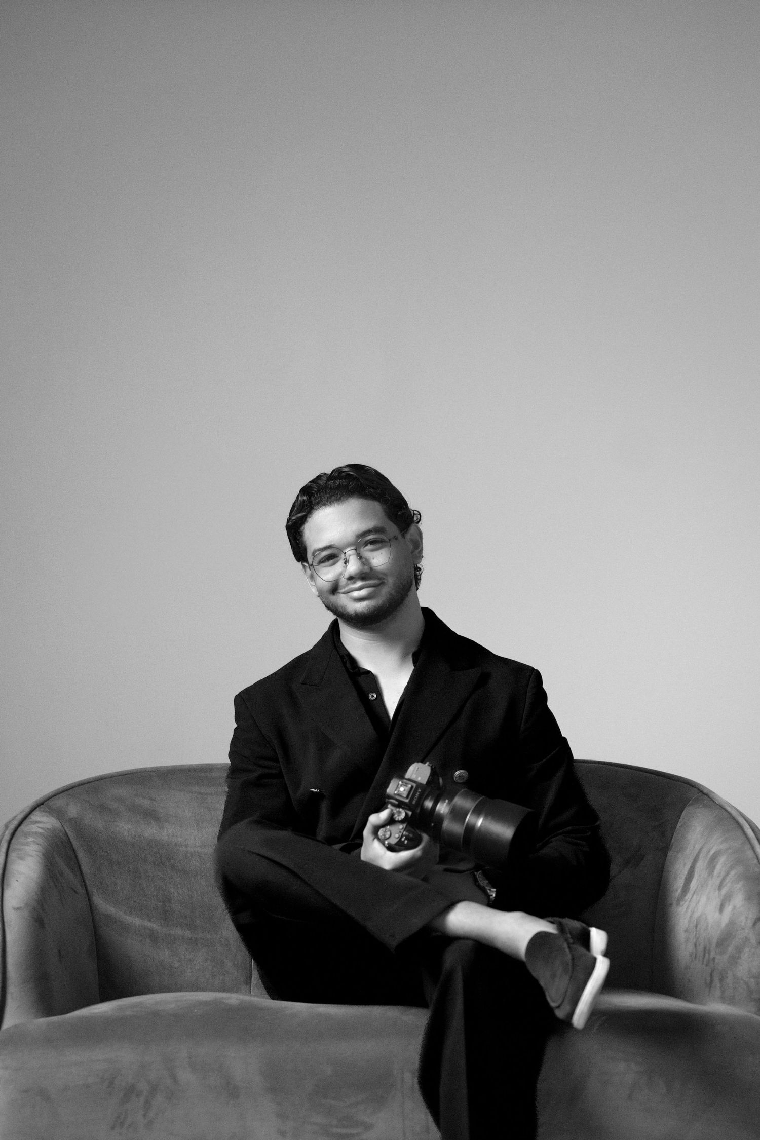 A black-and-white editorial portrait of José Ayala, captured with relaxed confidence and minimalist elegance.