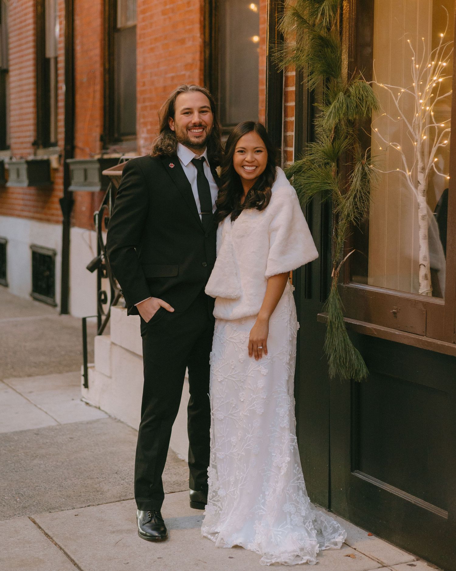 Elegant wedding portraits taken against brick buildings in an urban setting.