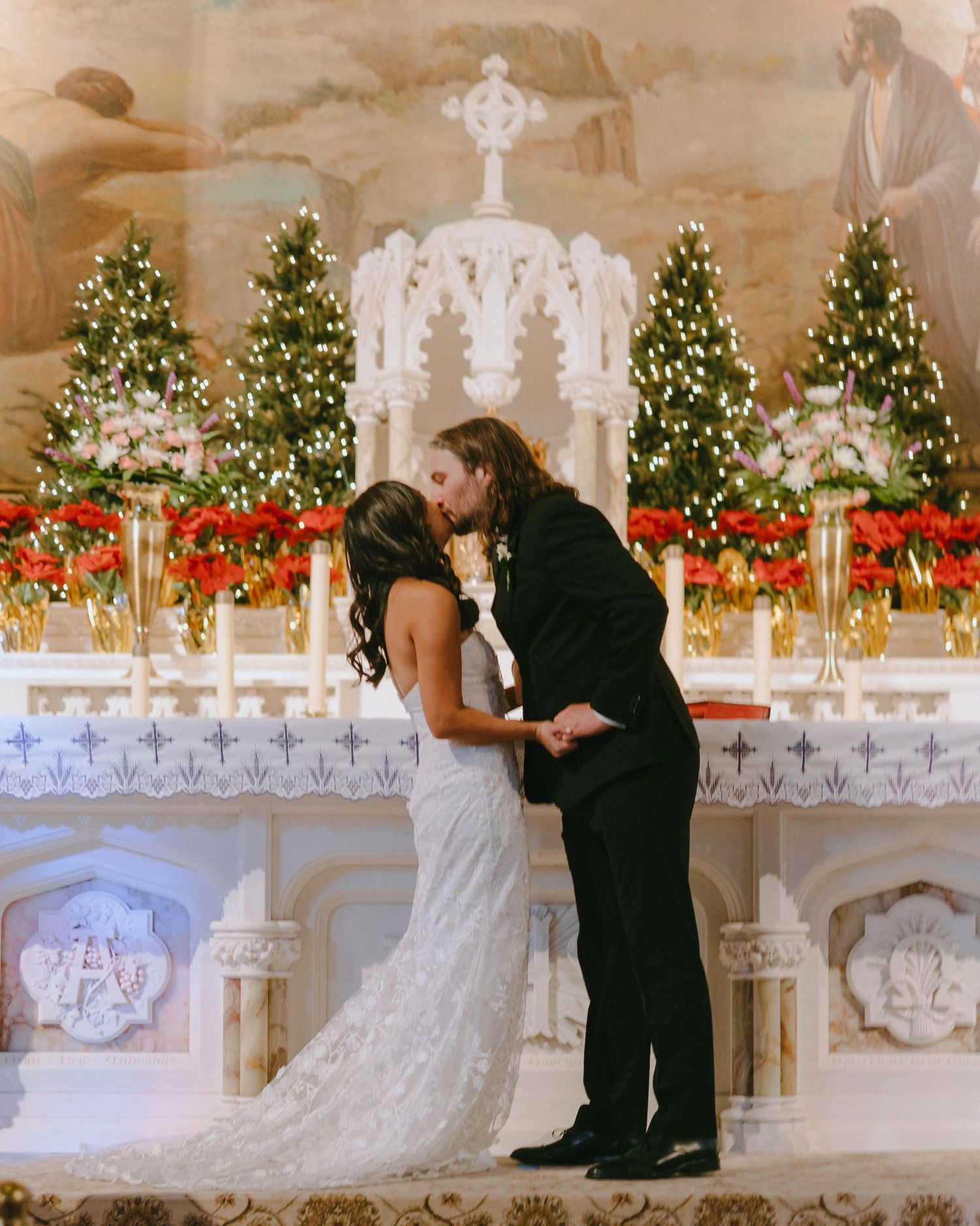 Couple sharing intimate moment at decorated church altar during Christmas season.