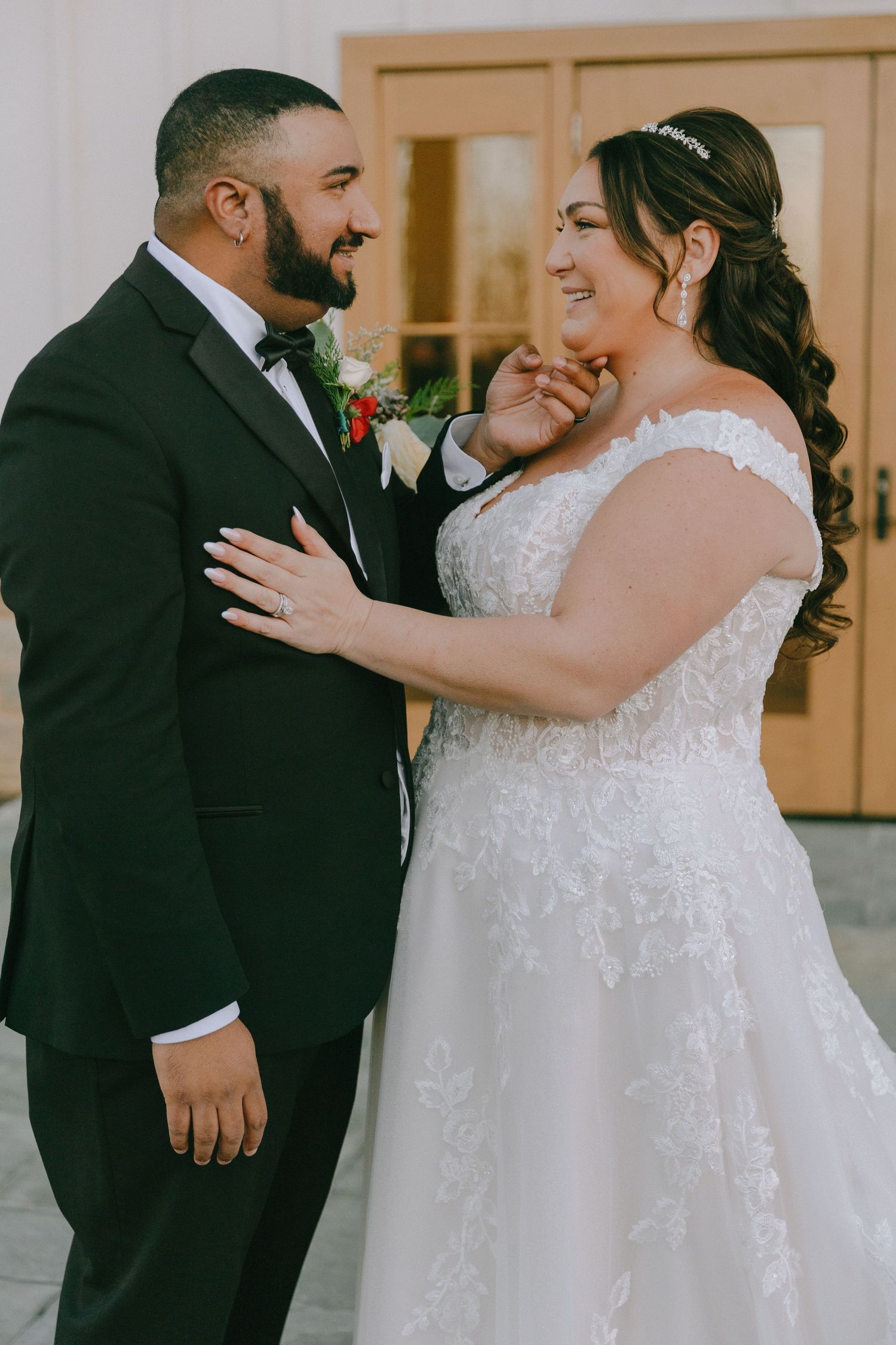 A romantic wedding moment captured with a couple in white dress and black tuxedo.