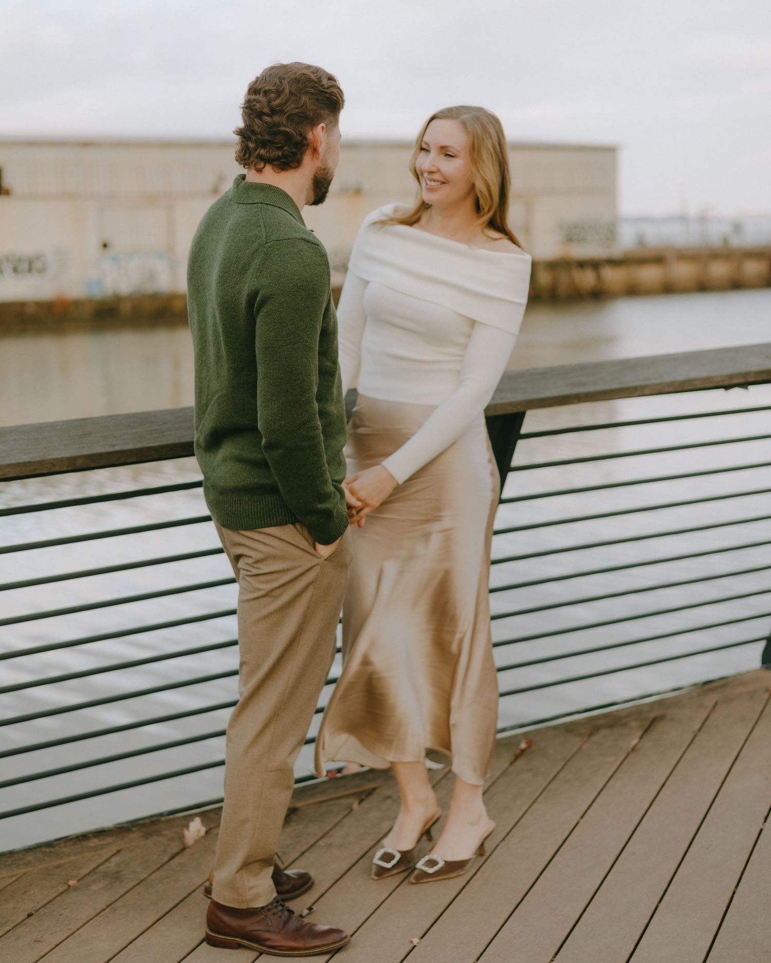 Two people sitting on a white bench outdoors in casual clothing having a candid moment.