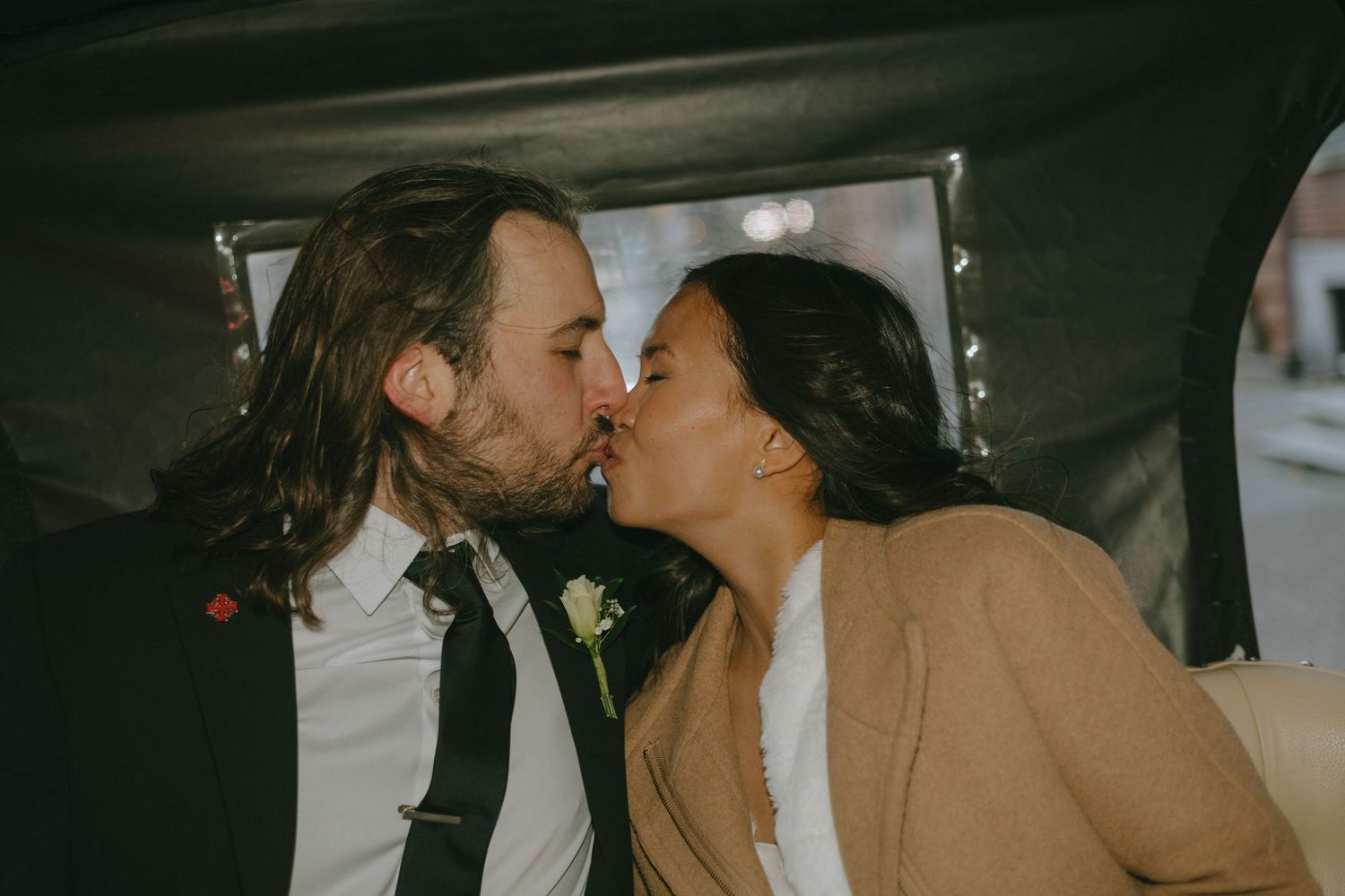 Intimate candid moments captured between the newlyweds in a dark setting.