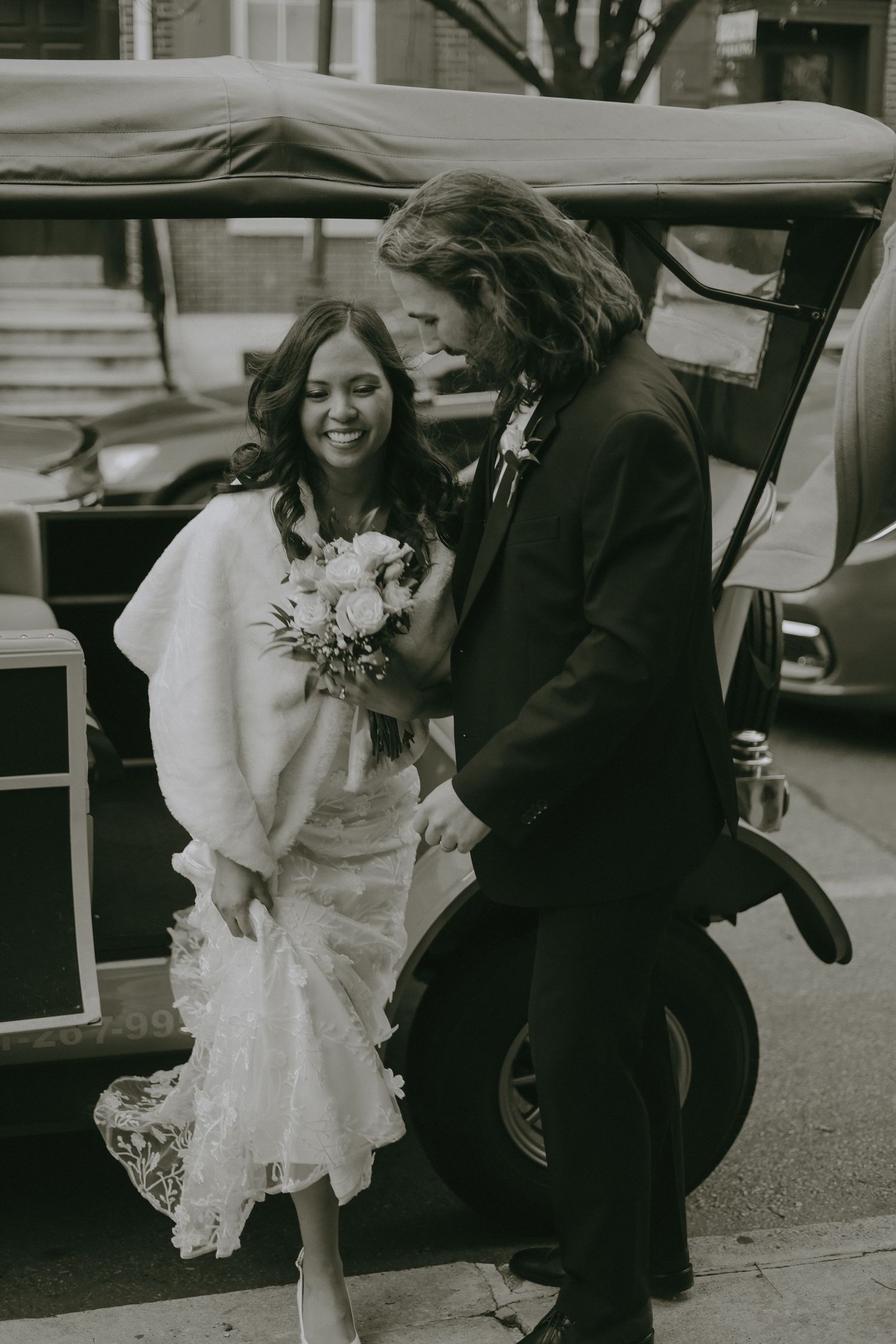 Candid laughter and joy shared between newlyweds on city street.